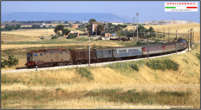 Sullo sfondo, la vecchia stazione ferroviaria di Poggio Imperiale (Foggia). In primo piano, un treno partito da Poggio Imperiale in direzione nord Italia. Nella foto la linea ferroviaria risulta già elettrificata ed il treno è trainato da un locomotore elettrico E.645 in circolazione dal 1958 Foto tratta da Facebook “Conosci Poggio Imperiale”