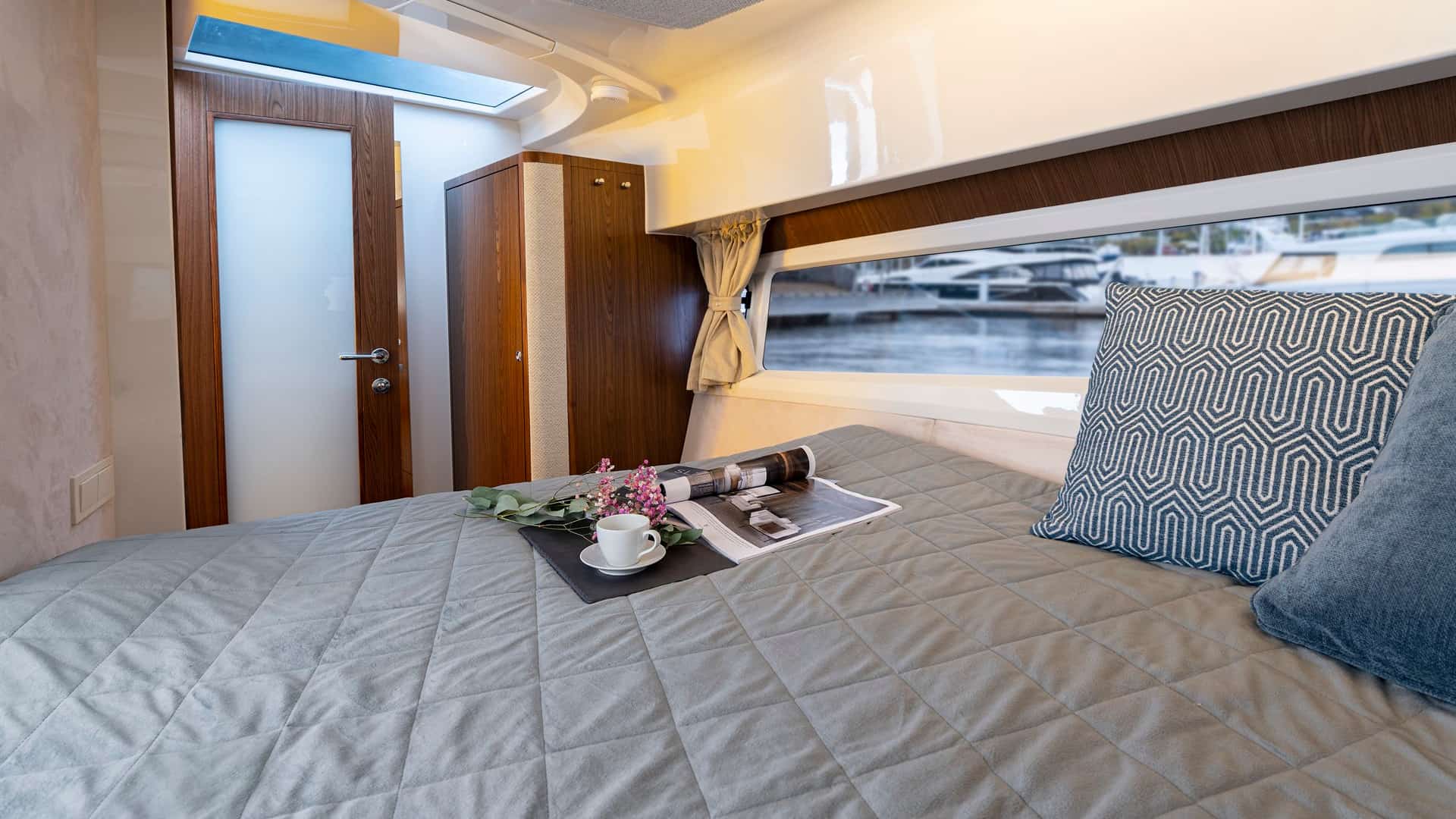 Das Foto zeigt die geräumige Bugkabine der Motoryacht Marex Scandinavia 330 mit großem Bett, Fenster und Schrank.