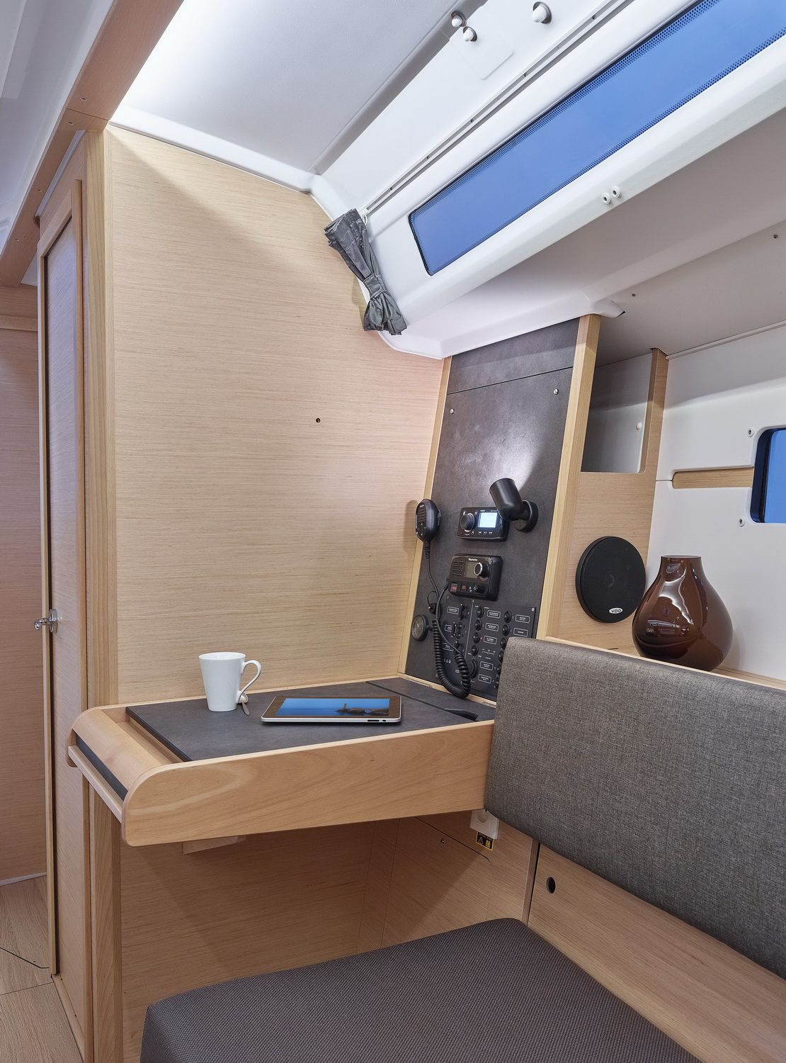 Innenraum der Jeanneau Sun Odyssey 349, Kartentisch mit Elektronikpanel, UKW-Funkgerät und Arbeitsplatz.