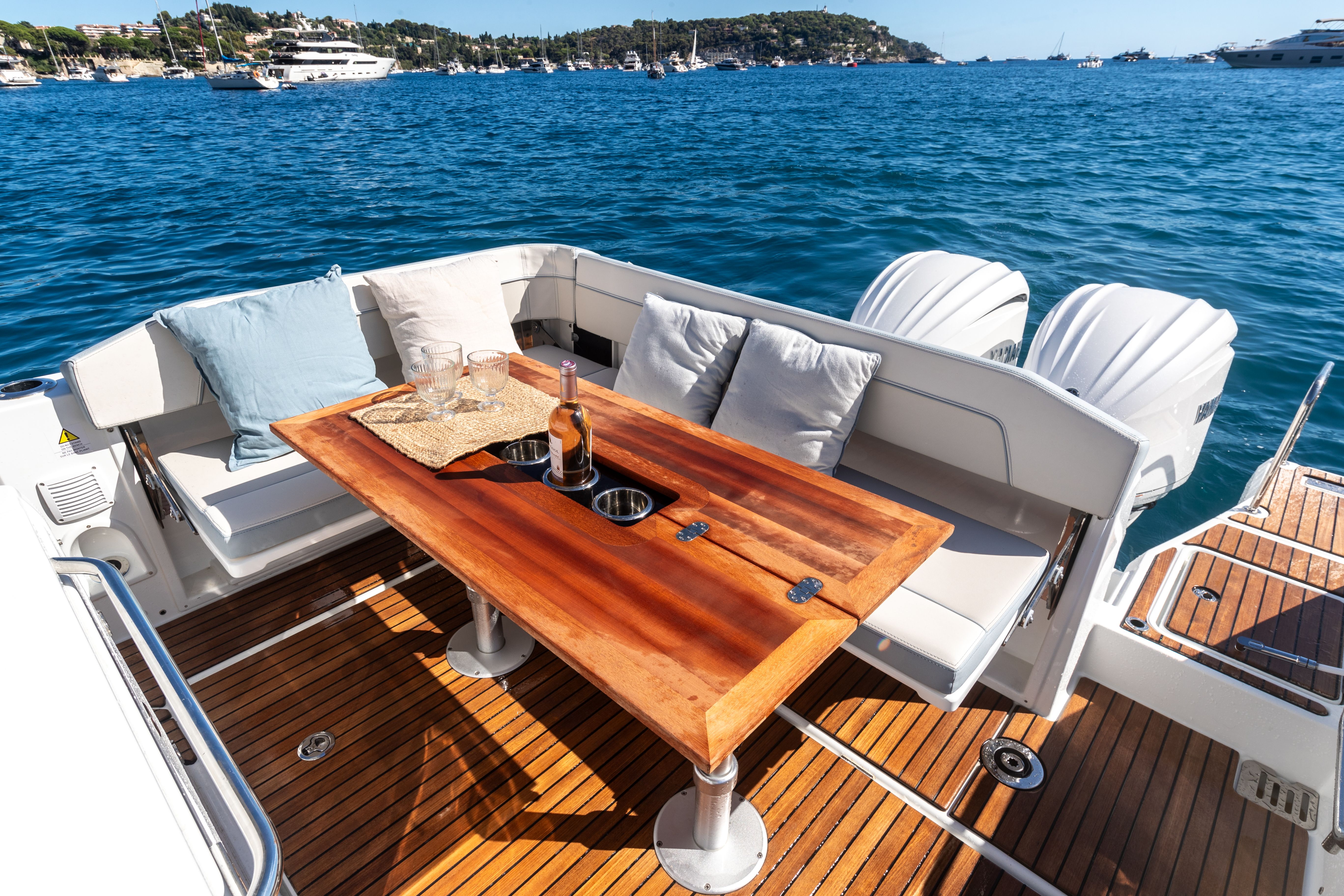View of the table and sofas on the aft deck of the Jeanneau Cap Camarat 9.0 CC Serie2 with twin outboard engines.