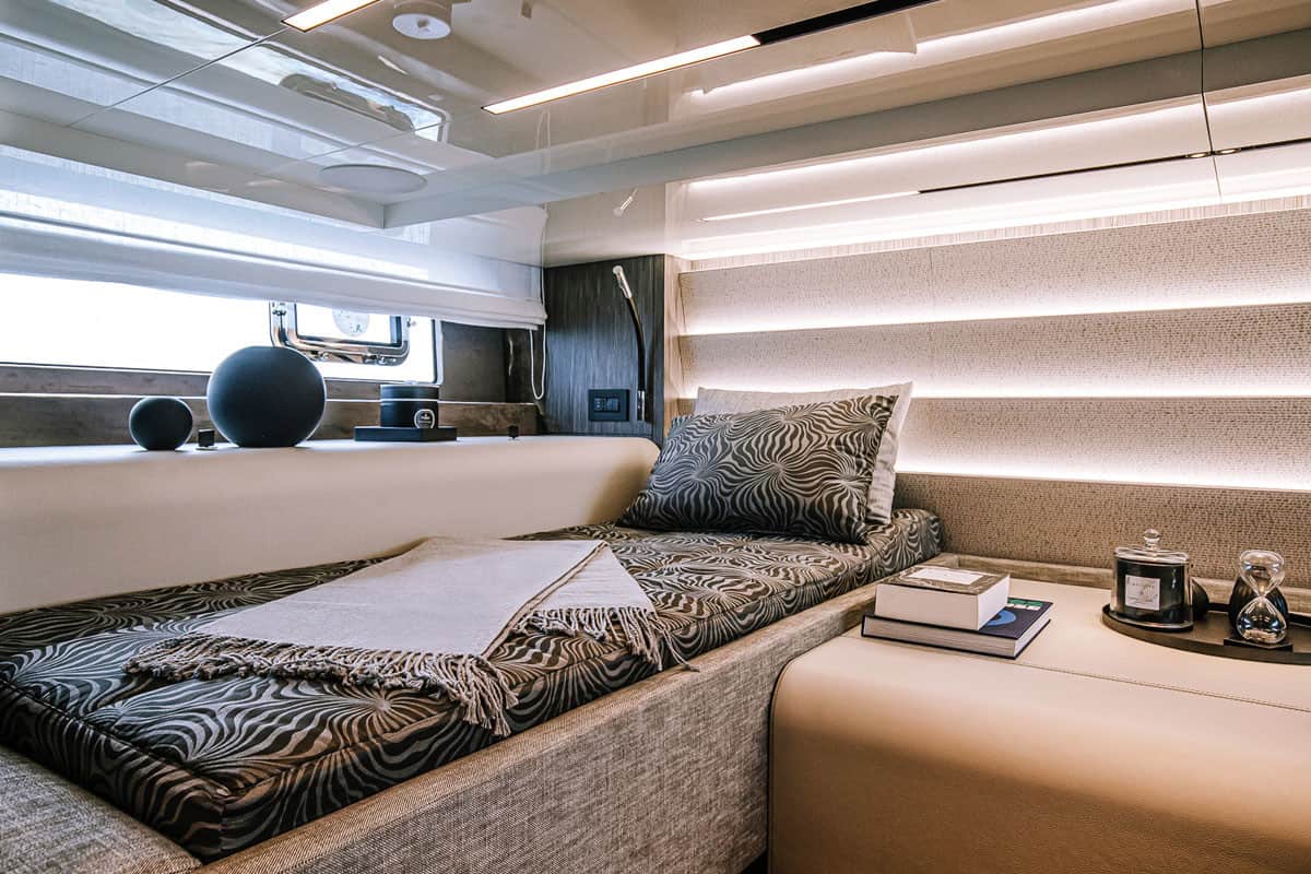 Wnętrze kabiny sypialnej jachtu Cranchi A46 Luxury Tender z łóżkiem, oknem i oświetleniem.