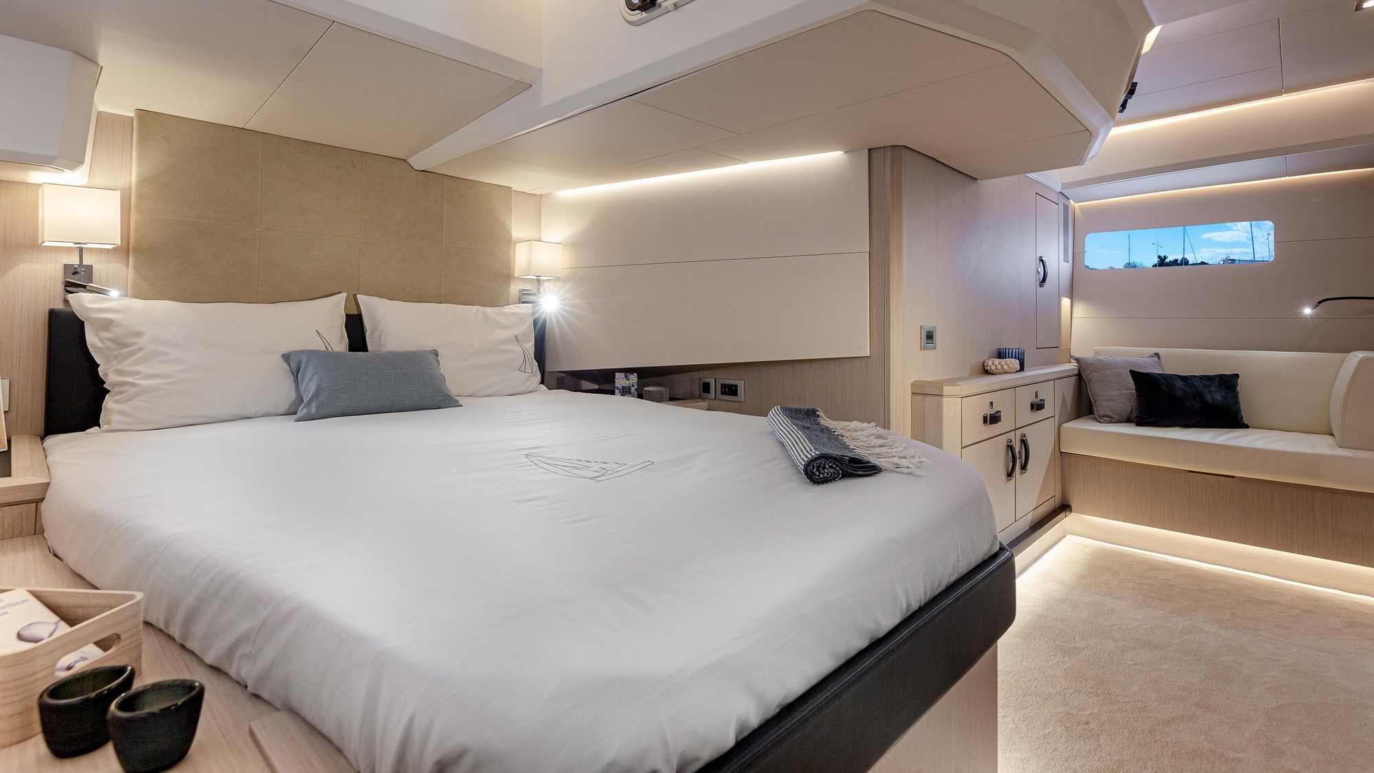Innenraum der Eignerkabine auf der Jeanneau Yachts 60 mit großem Bett, Sofa und Schränken.