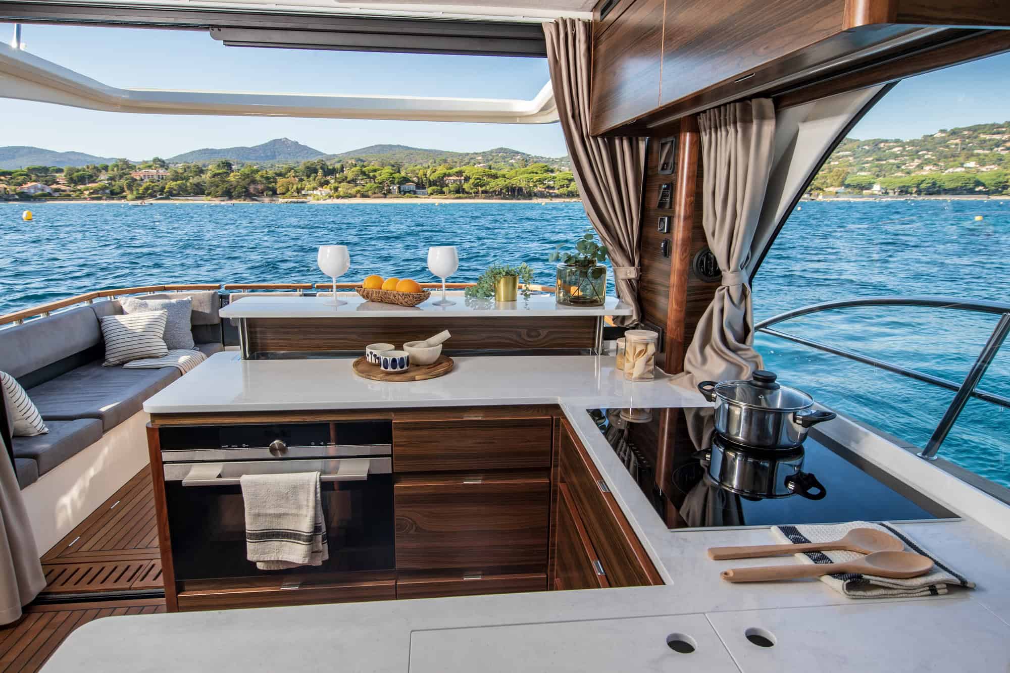 Blick auf Küchenzeile und Salon der Marex 440 Gourmet Cruiser mit offenem Blick auf Meer und Küste.