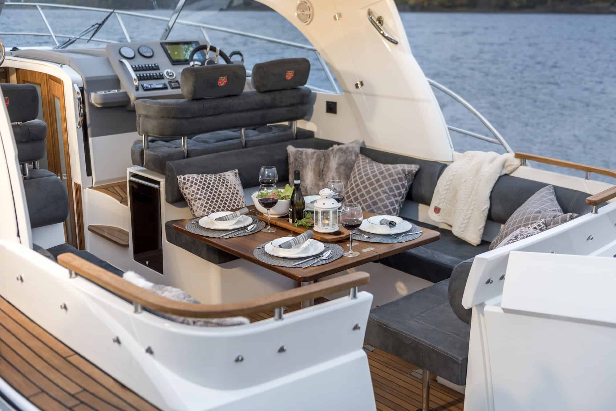 Widok na przestronny kokpit jachtu Marex 310 Sun Cruiser z ustawionym stołem jadalnym i wygodnymi miejscami do siedzenia.