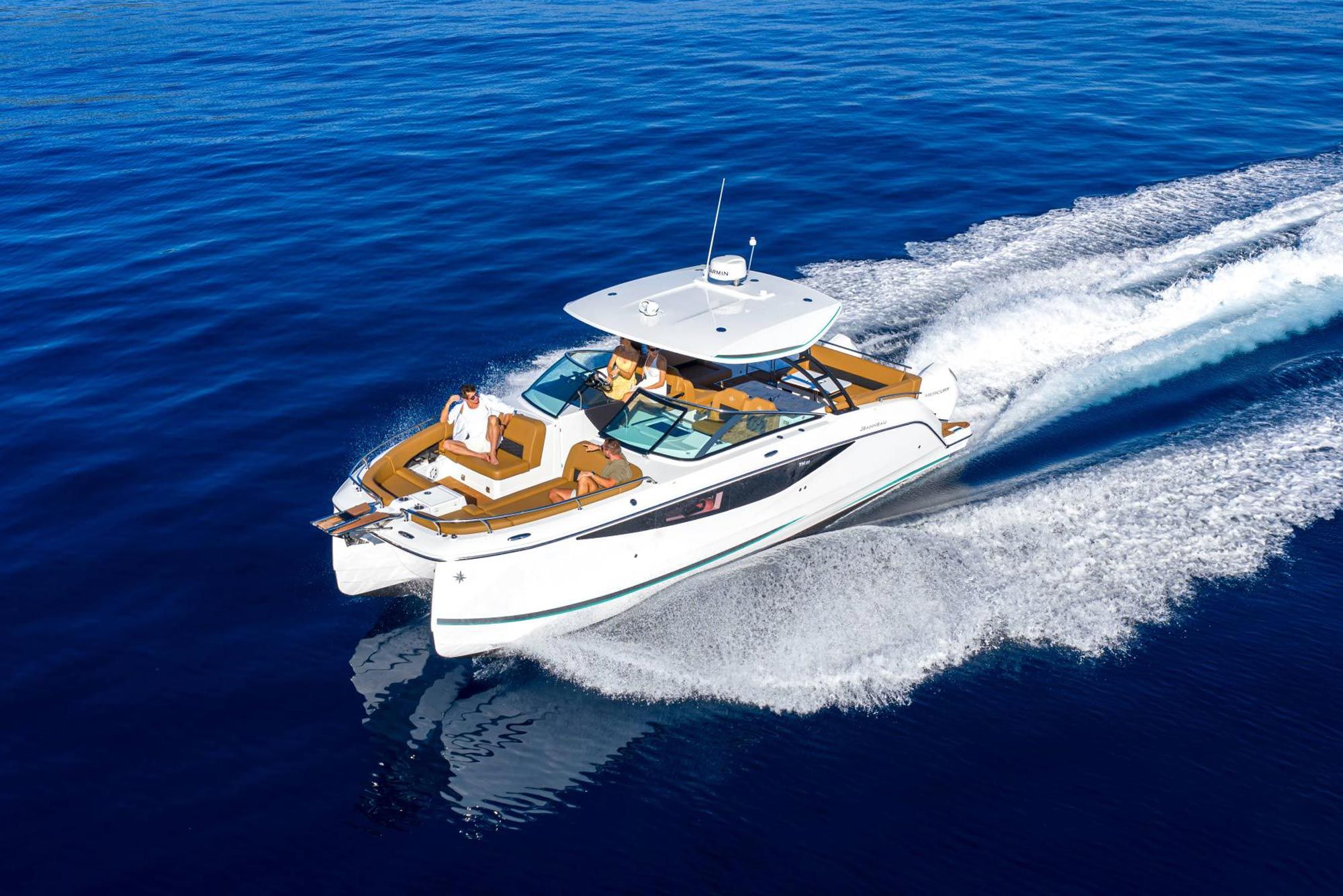 Jeanneau TH33, a modern power catamaran, sailing on blue water, with people relaxing on the wide deck.