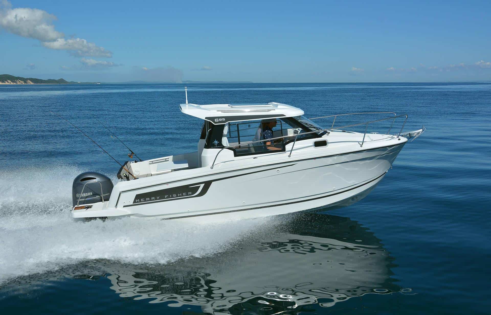 Biała motorówka Jeanneau Merry Fisher 695 Serie 2 z silnikiem Yamaha płynąca po morzu, tworząca falę.