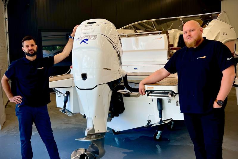 Mechanics at the outboard engine in the hall