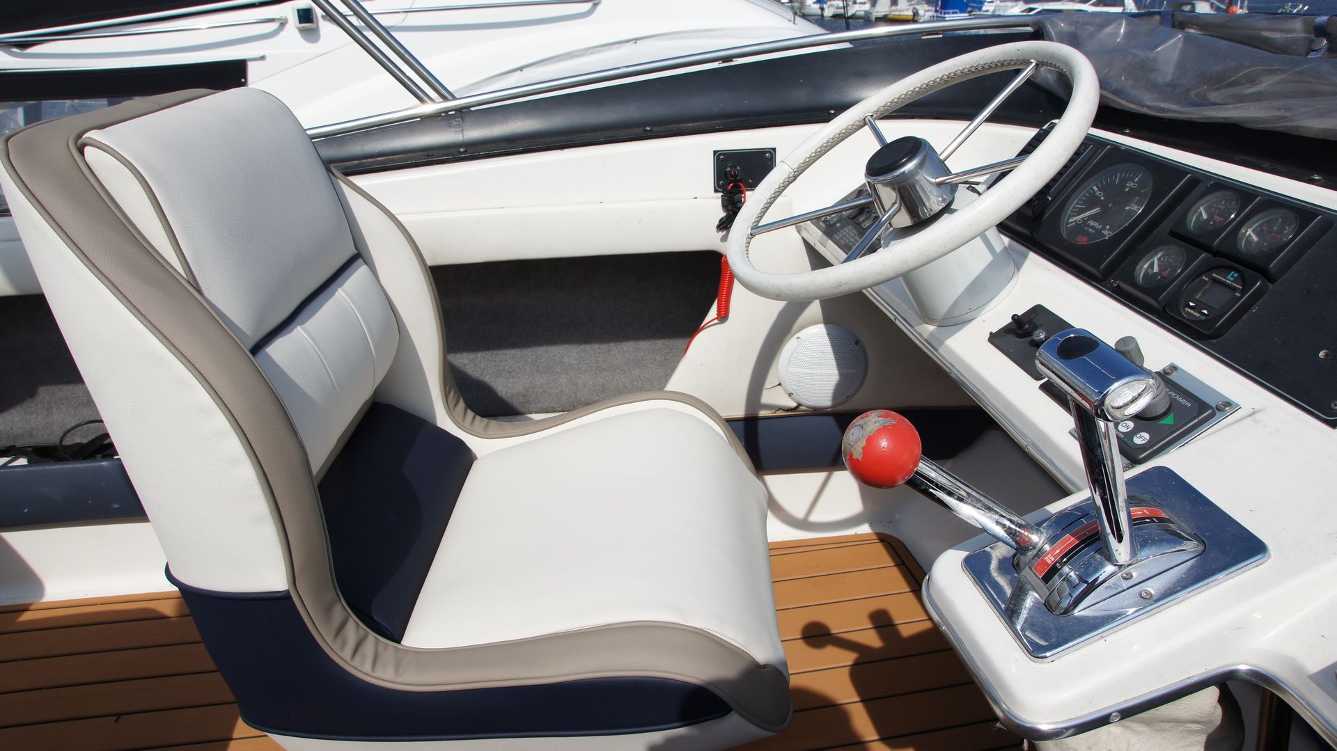 Widok na stanowisko sterowe na Flybridge jachtu Bayliner 2858 Classic Fly z kierownicą, manetkami i nową tapicerką.