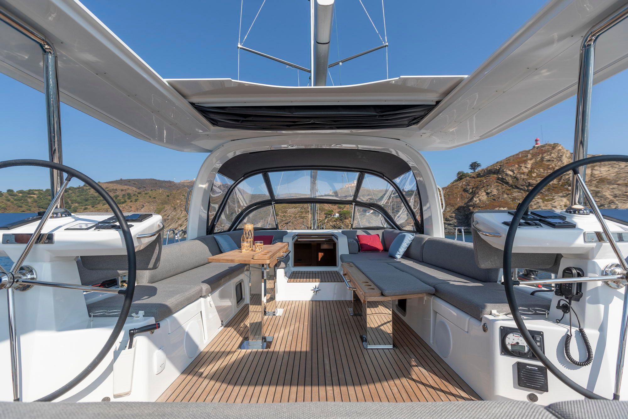 Widok na przestronny kokpit jachtu żaglowego Jeanneau Yachts 60 z dwoma kołami sterowymi i miejscami do siedzenia.