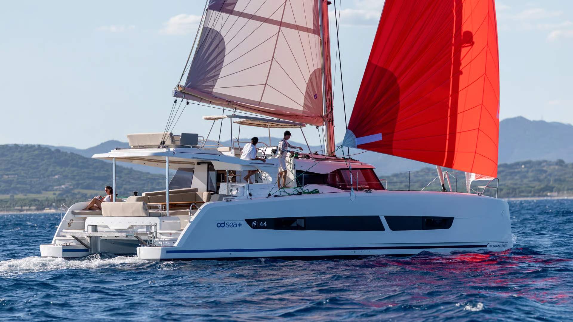 Katamaran Fountaine Pajot FP44 płynący po morzu z rozwiniętymi żaglami. Widoczni ludzie na pokładzie.