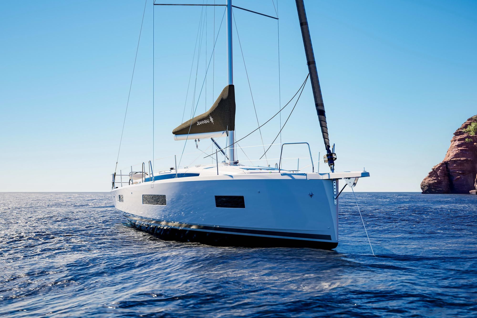 Blick auf den Bug der Segelyacht Jeanneau Sun Odyssey 455 auf offener See, mit teilweise gerefftem Segel und blauem Himmel.
