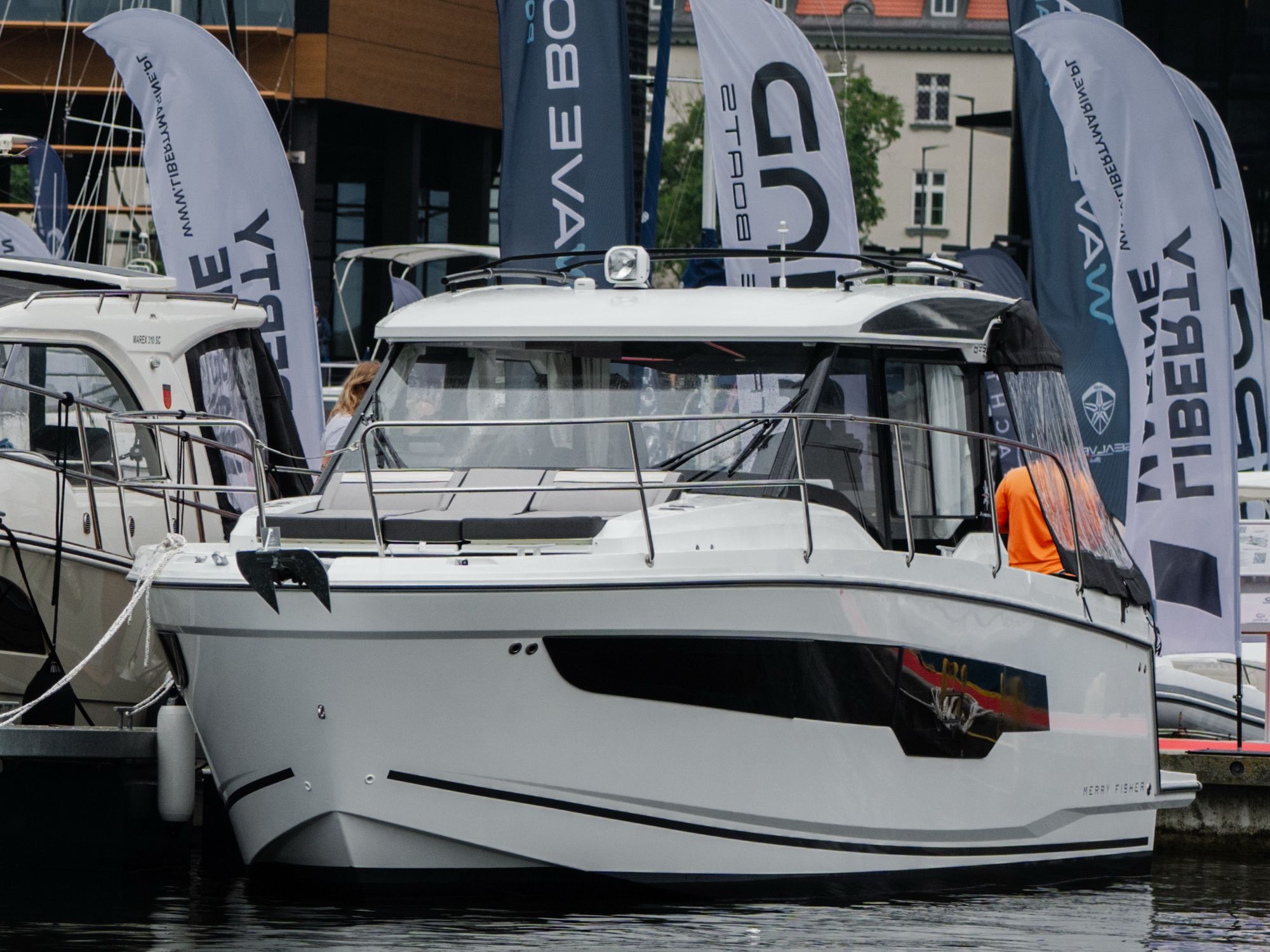 White Jeanneau Merry Fisher 895 Serie 2 motor yacht moored at a jetty, front and side view.