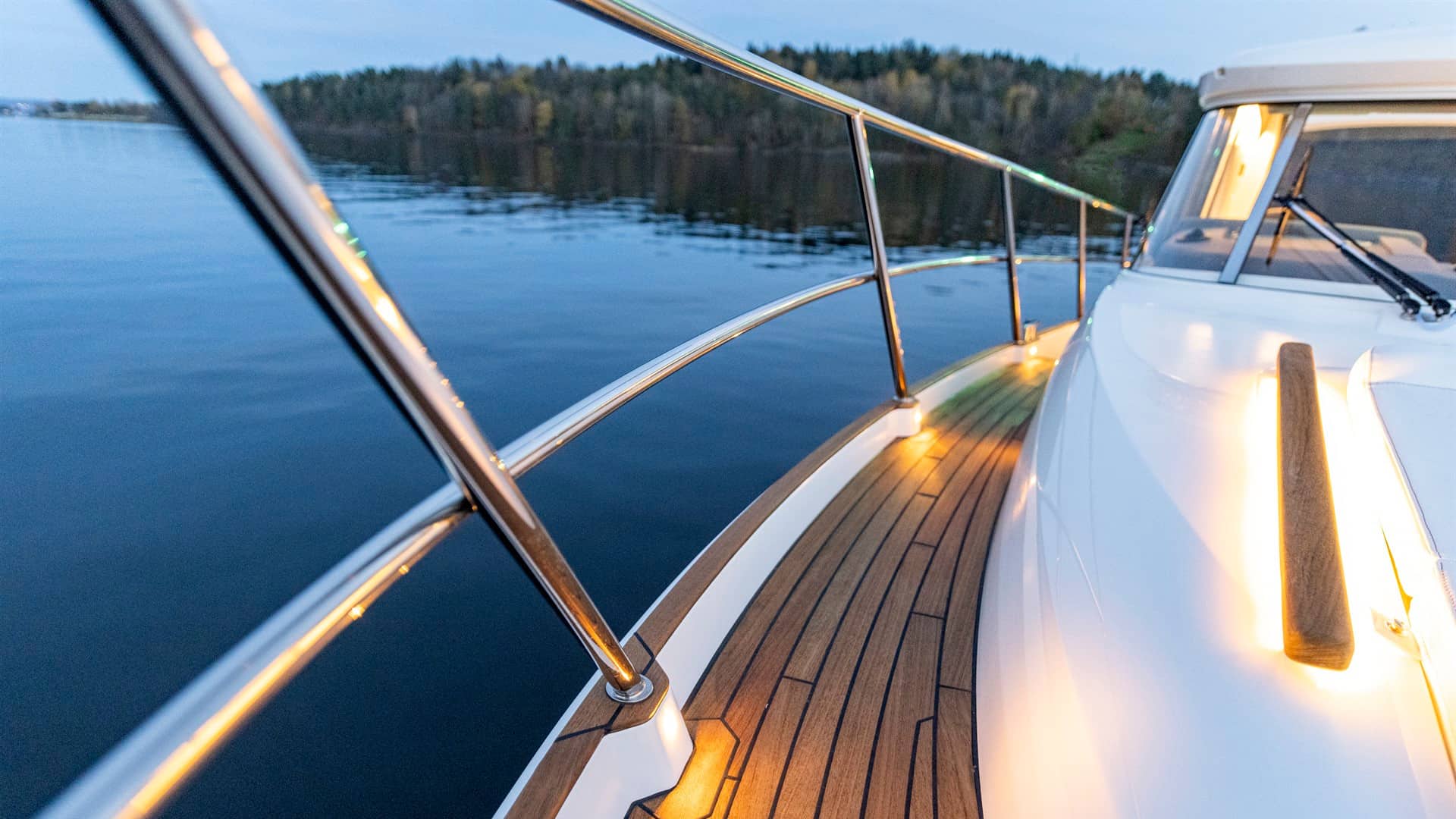 Widok na pokład dziobowy jachtu Marex Scandinavia 330 z relingami, oświetleniem pokładowym i tekowym wykończeniem.