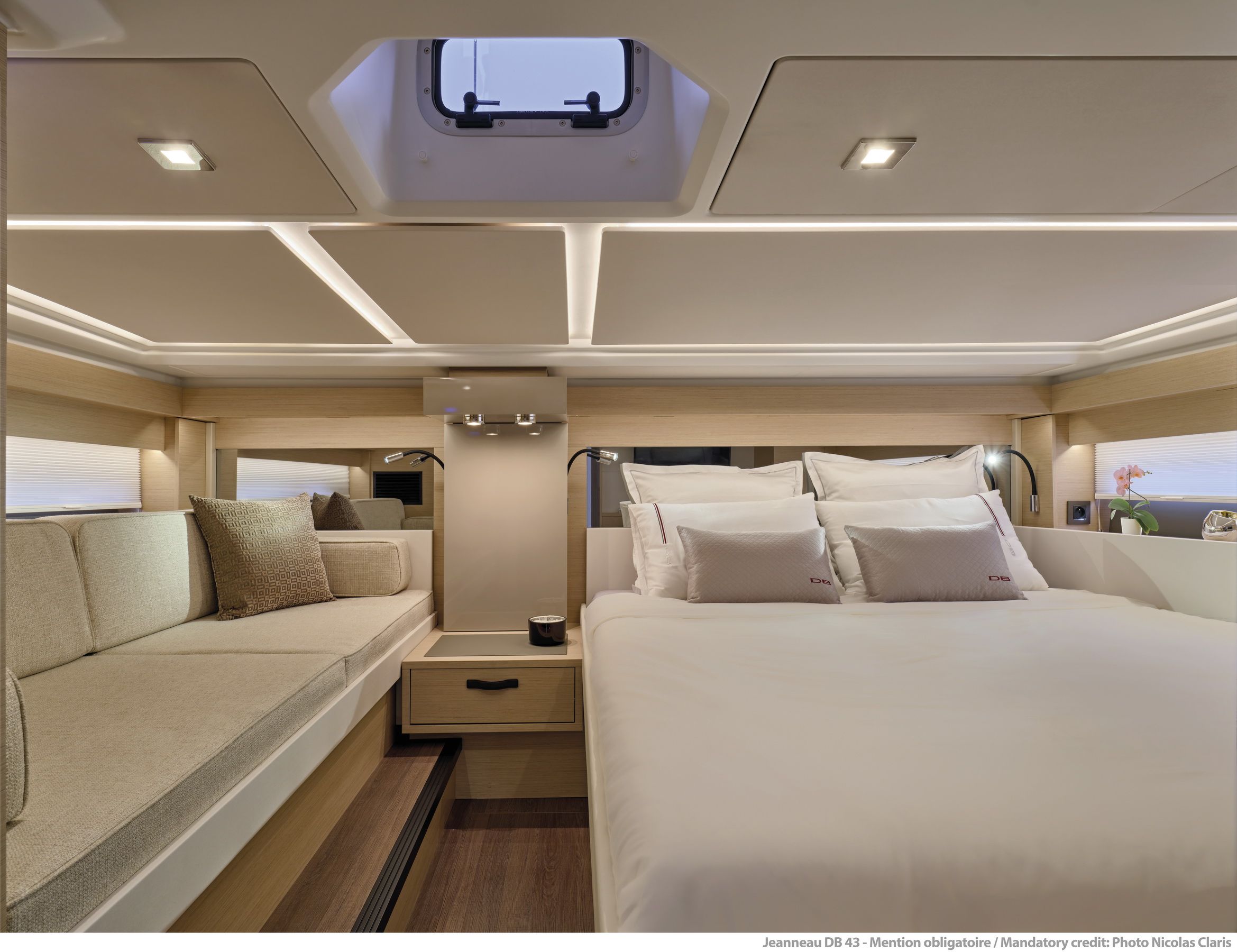 Interior of the sleeping cabin on the Jeanneau DB/43 OB with a large berth, sofa and roof window.