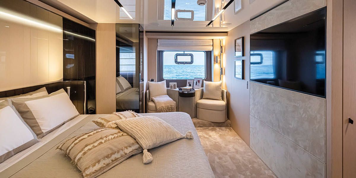 Luxurious sleeping cabin aboard the Cranchi Sessantasette 67 with a large bed, a window with sea views and a TV.