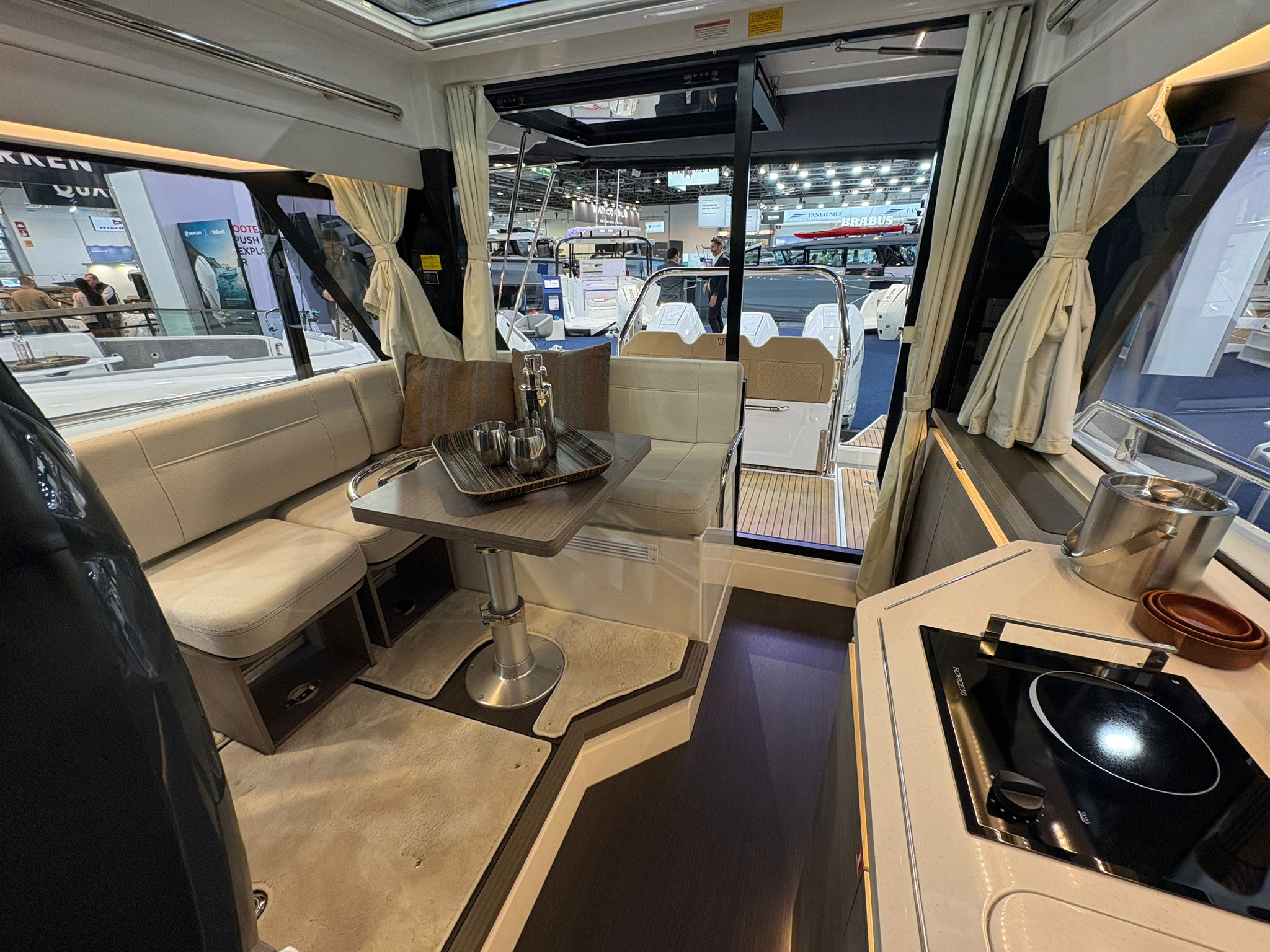 Wnętrze jachtu Wellcraft 38 Explorer z salonem, stołem i aneksem kuchennym. Widok na kokpit zewnętrzny.