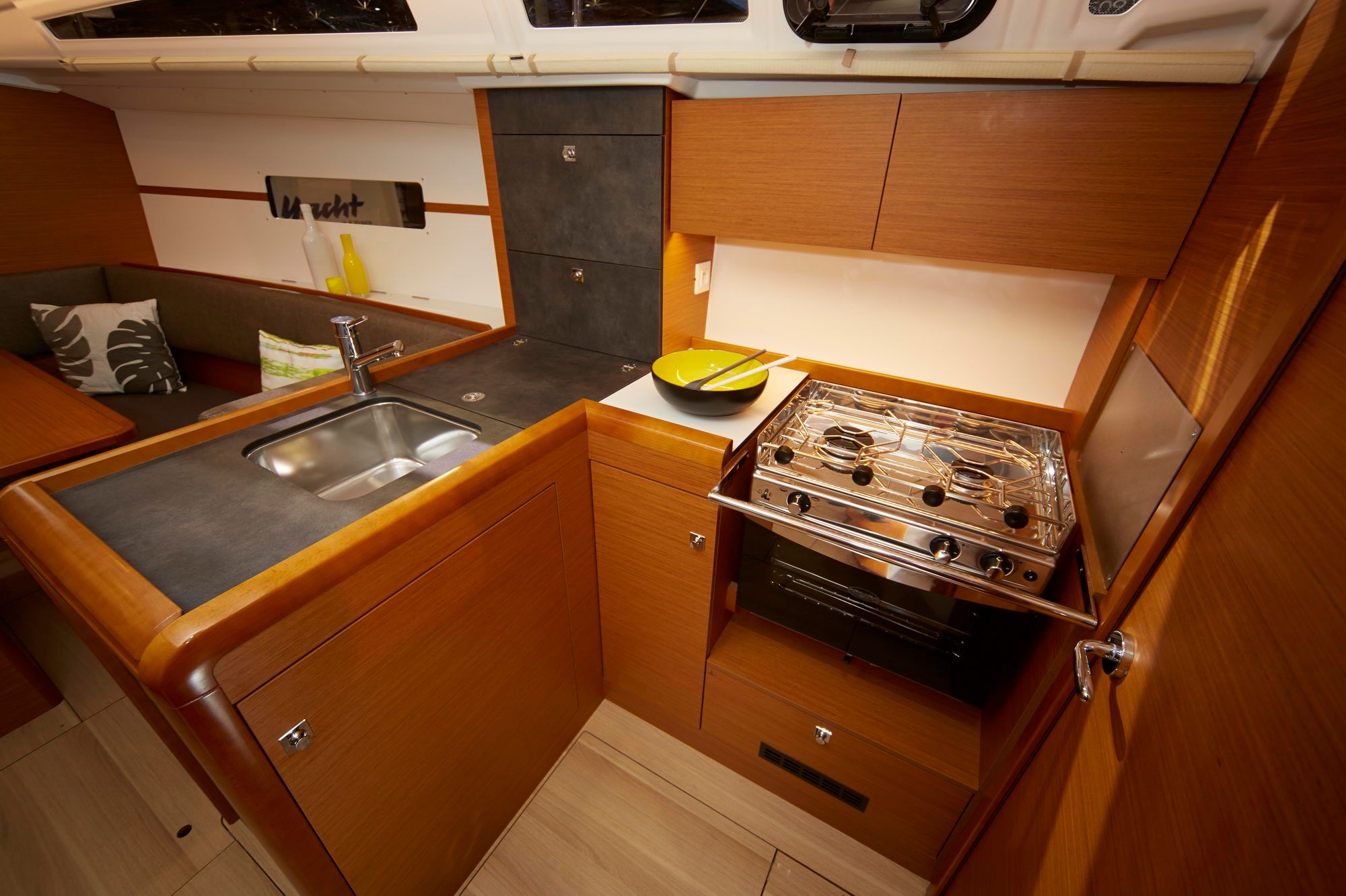 Widok na kambuz jachtu żaglowego Jeanneau Sun Odyssey 349 z kuchenką, piekarnikiem i zlewem.