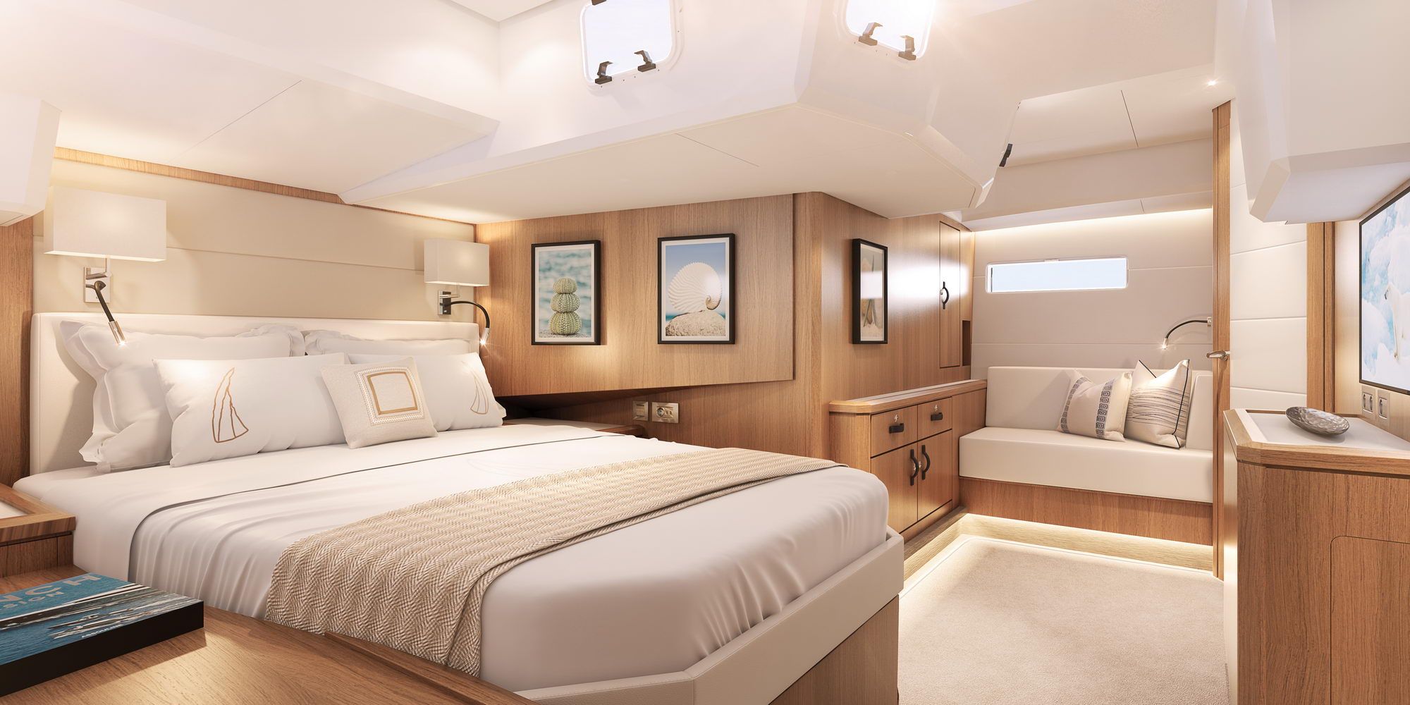 Luxurious owner's cabin on the Jeanneau Yachts 60 with a large bed, wood panelling, sofa and hull windows.