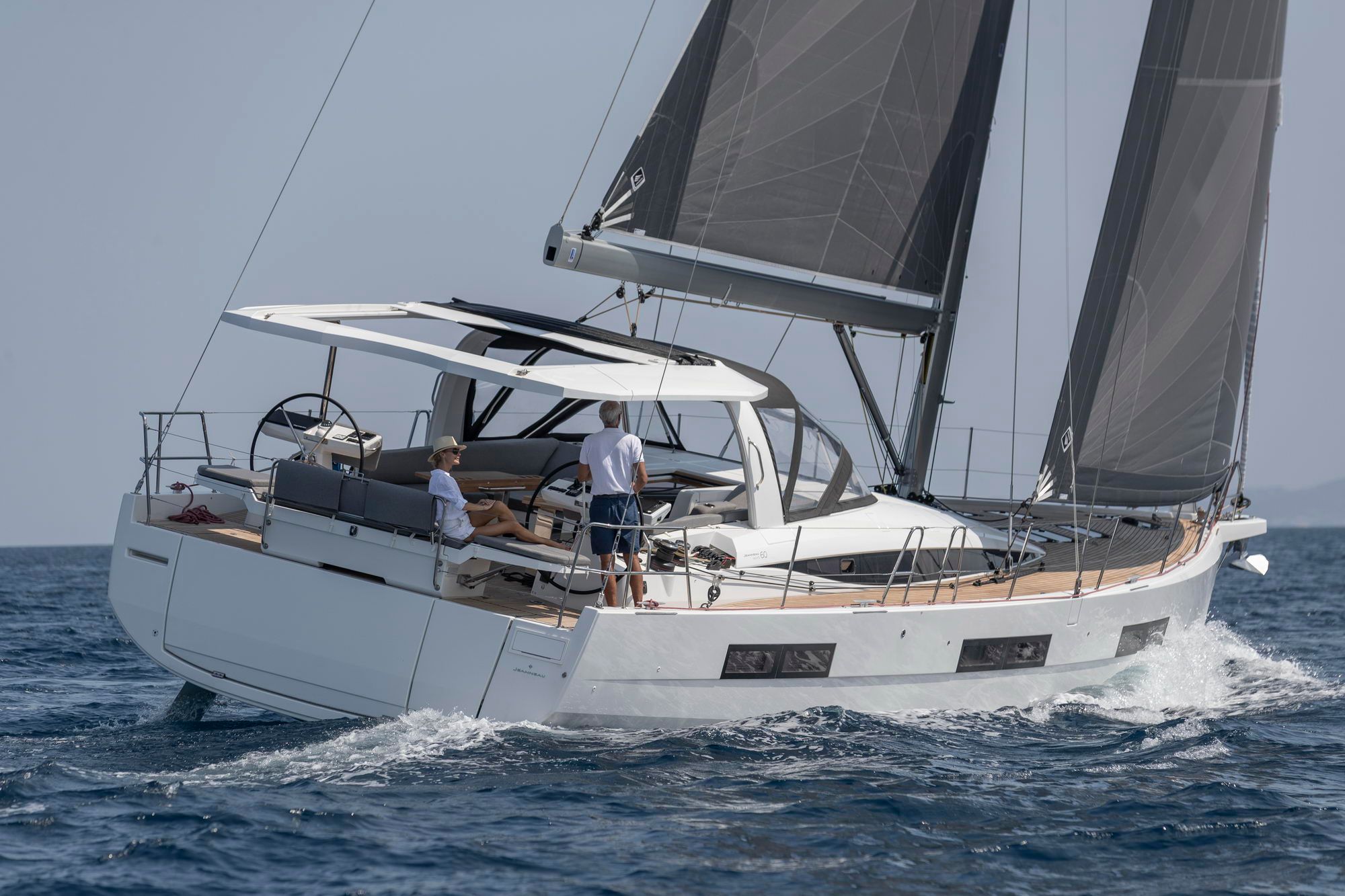 Jeanneau Yachts 60, jacht żaglowy płynący po morzu z dwoma osobami w kokpicie i rozłożonymi żaglami.