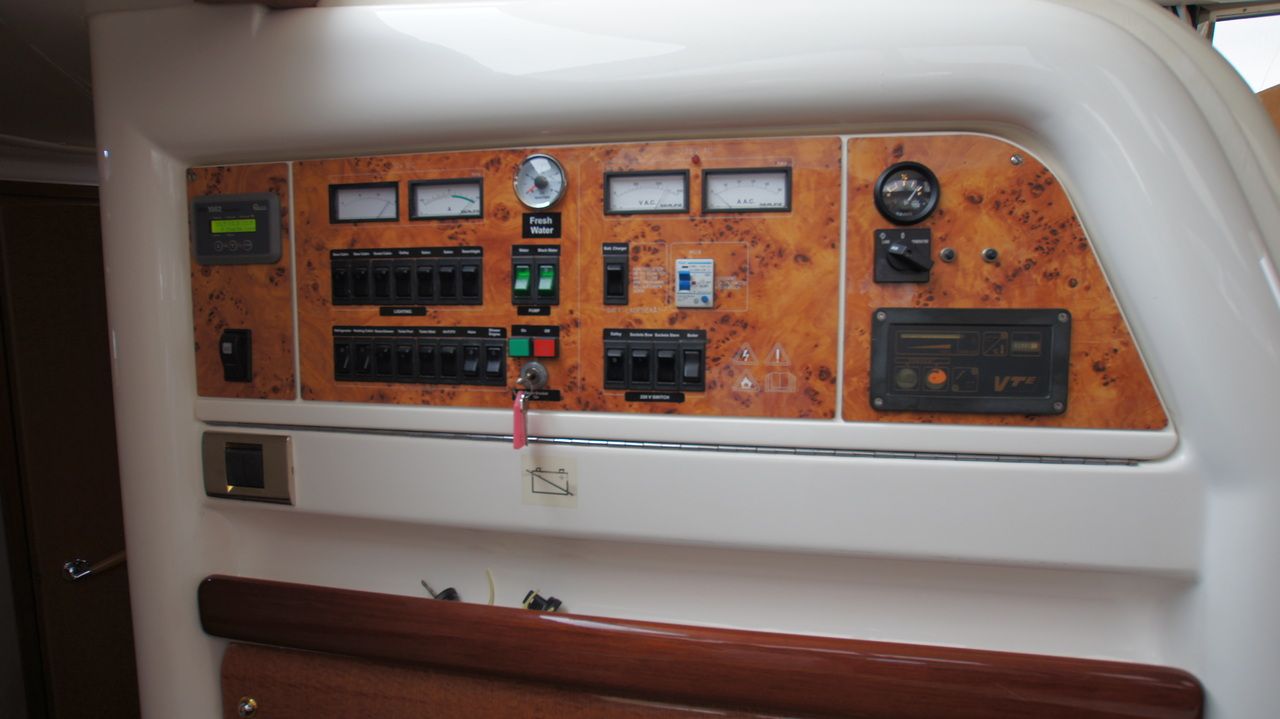 Panel sterowania elektrycznego jachtu Sealine F44 Flybridge z przełącznikami, wskaźnikami i radiem.