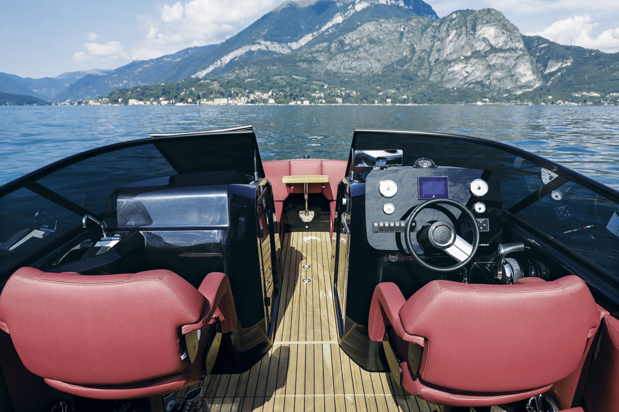 Blick vom Cockpit der E26 Rider nach vorn - Bedienpanel und Sitze, vor dem Boot ein Bergsee.