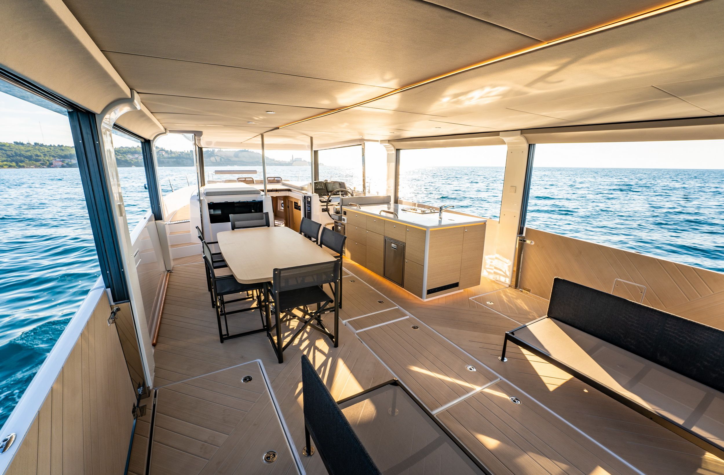 Interior of the Jeanneau Sea Loft 480 motor yacht with the saloon, kitchen and a sea view.