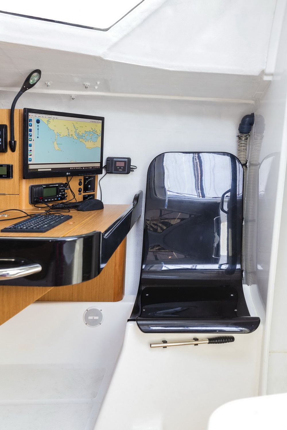 Innenraum der Sun Fast 3300 mit Navigationsstation, Kartendisplay, Funkgerät und ergonomischem Sitz.