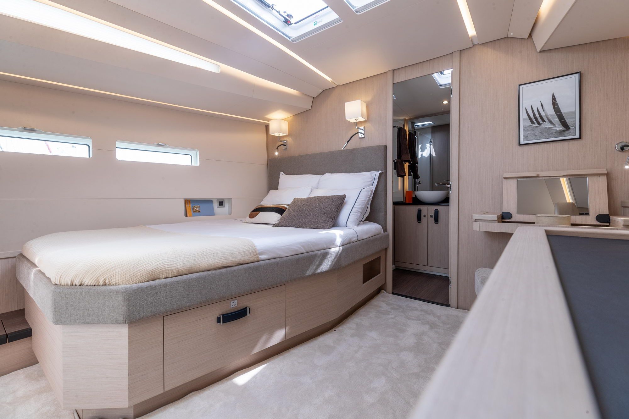Sypialnia armatora z podwójnym łóżkiem, oknami i wejściem do łazienki na jachcie Jeanneau Yachts 55.