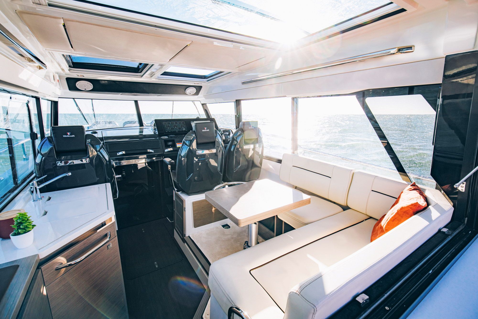 Wnętrze jachtu Wellcraft 38 Explorer z widokiem na sterówkę, aneks kuchenny i salon.