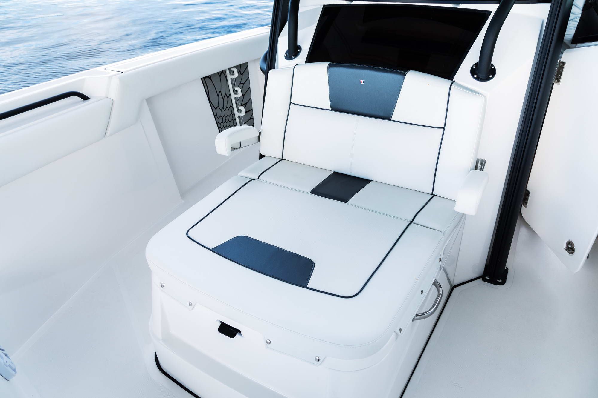 Ergonomiczny fotel sternika na pokładzie Wellcraft Fisherman 352, tapicerowany w bieli i szarości, z widokiem na morze.