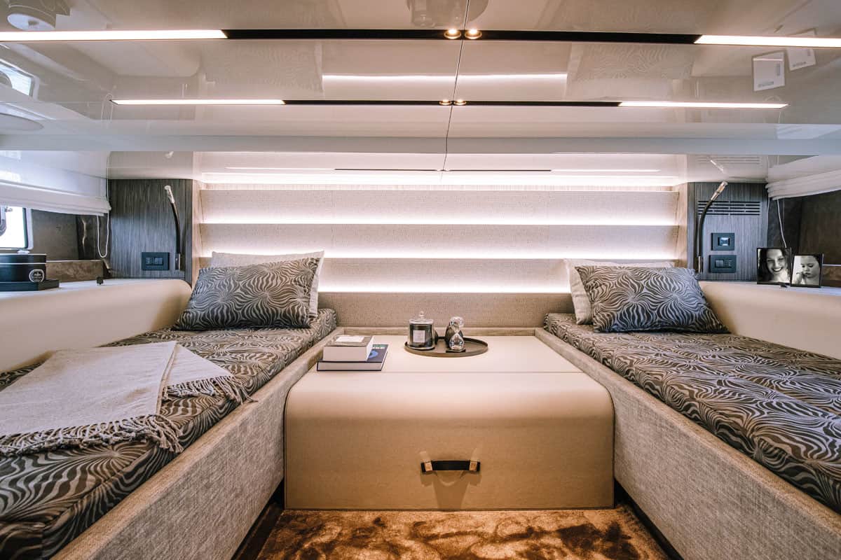Wnętrze kabiny sypialnej jachtu Cranchi A46 Luxury Tender z dwoma pojedynczymi łóżkami i centralnym stolikiem.