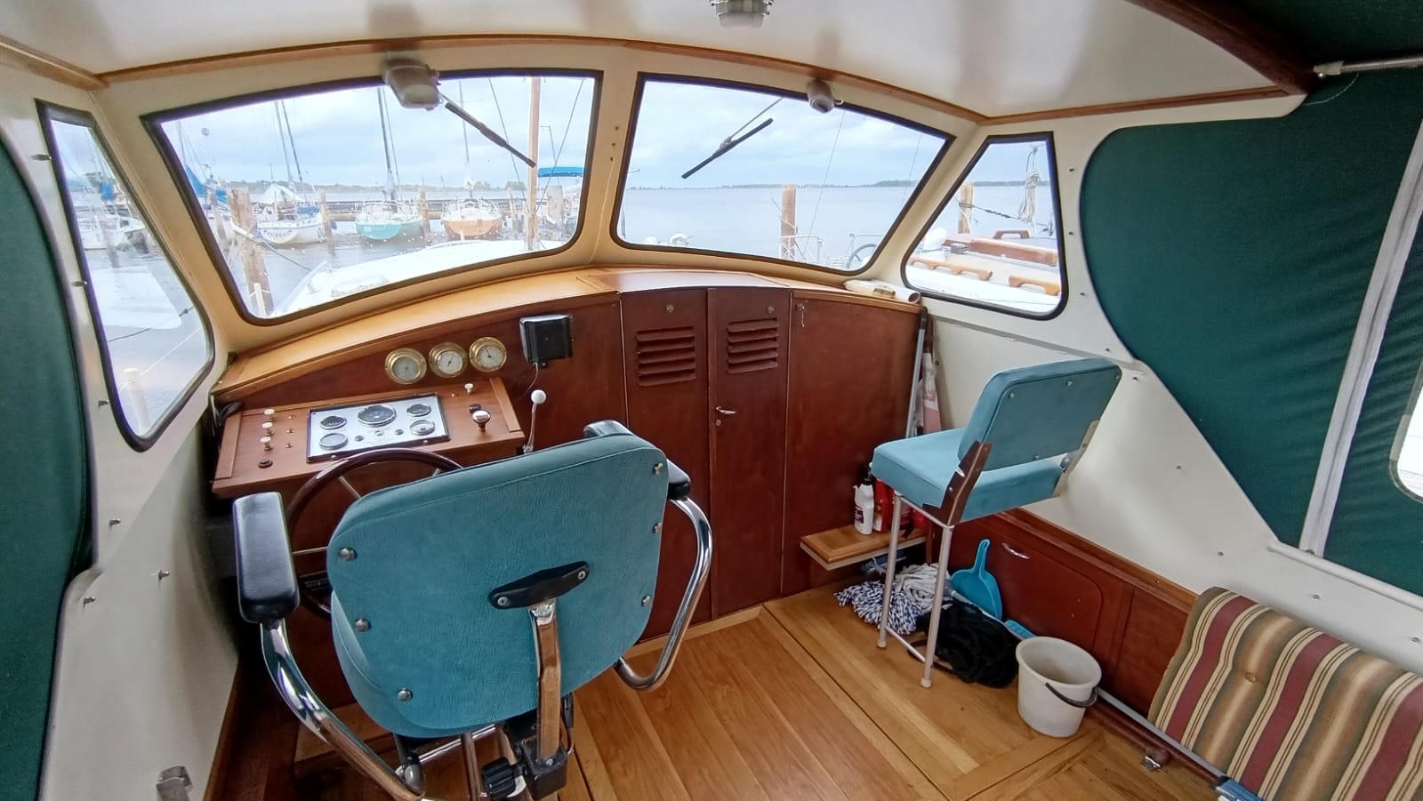 Innenraum des Steuerstands des Stahl-Motorboots Aquanaut 750 mit Blick auf die Marina.