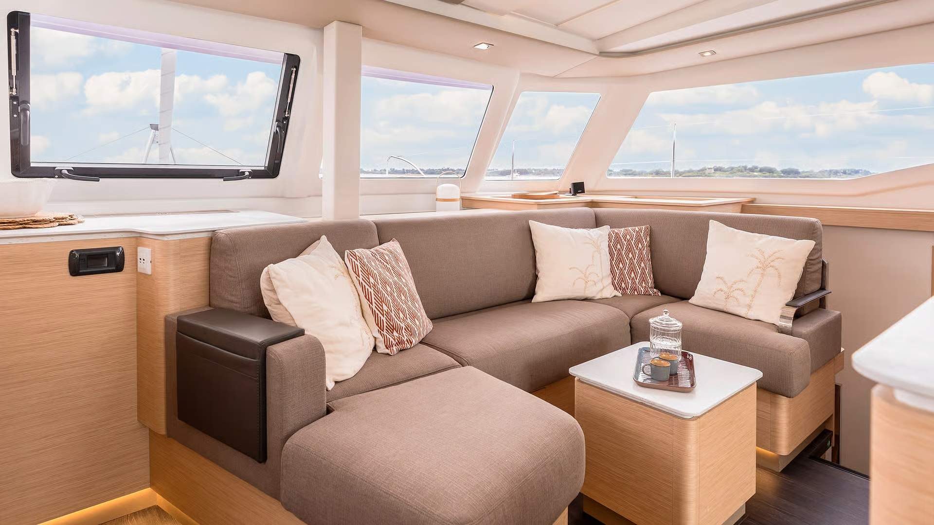 Wnętrze salonu katamaranu Fountaine Pajot FP41 z dużą sofą i panoramicznymi oknami.