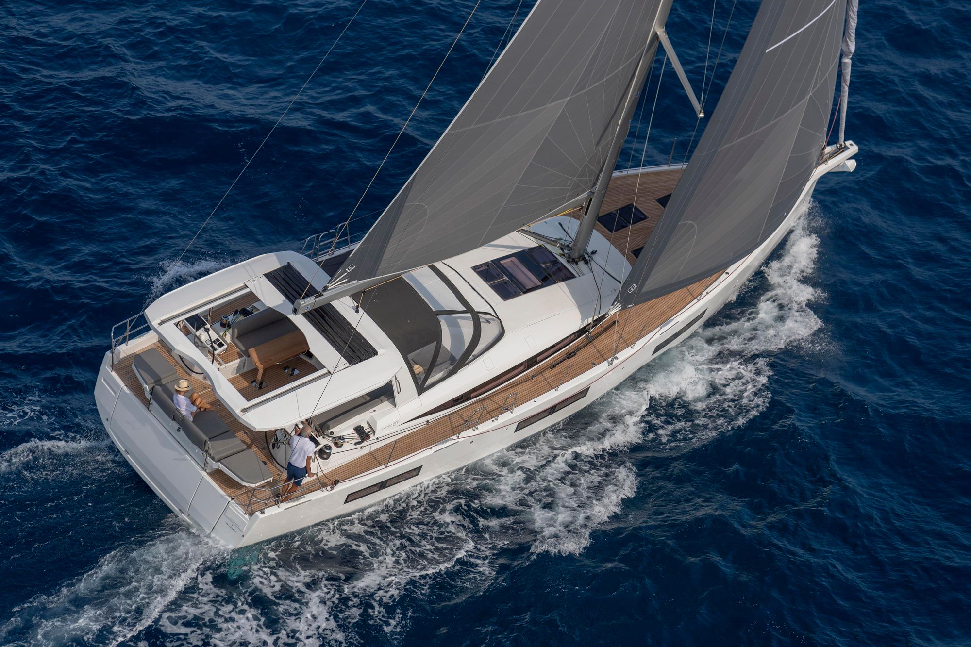 Jeanneau Yachts 60 płynący po otwartym morzu, widok z góry na pokład, kokpit i rozłożone żagle.