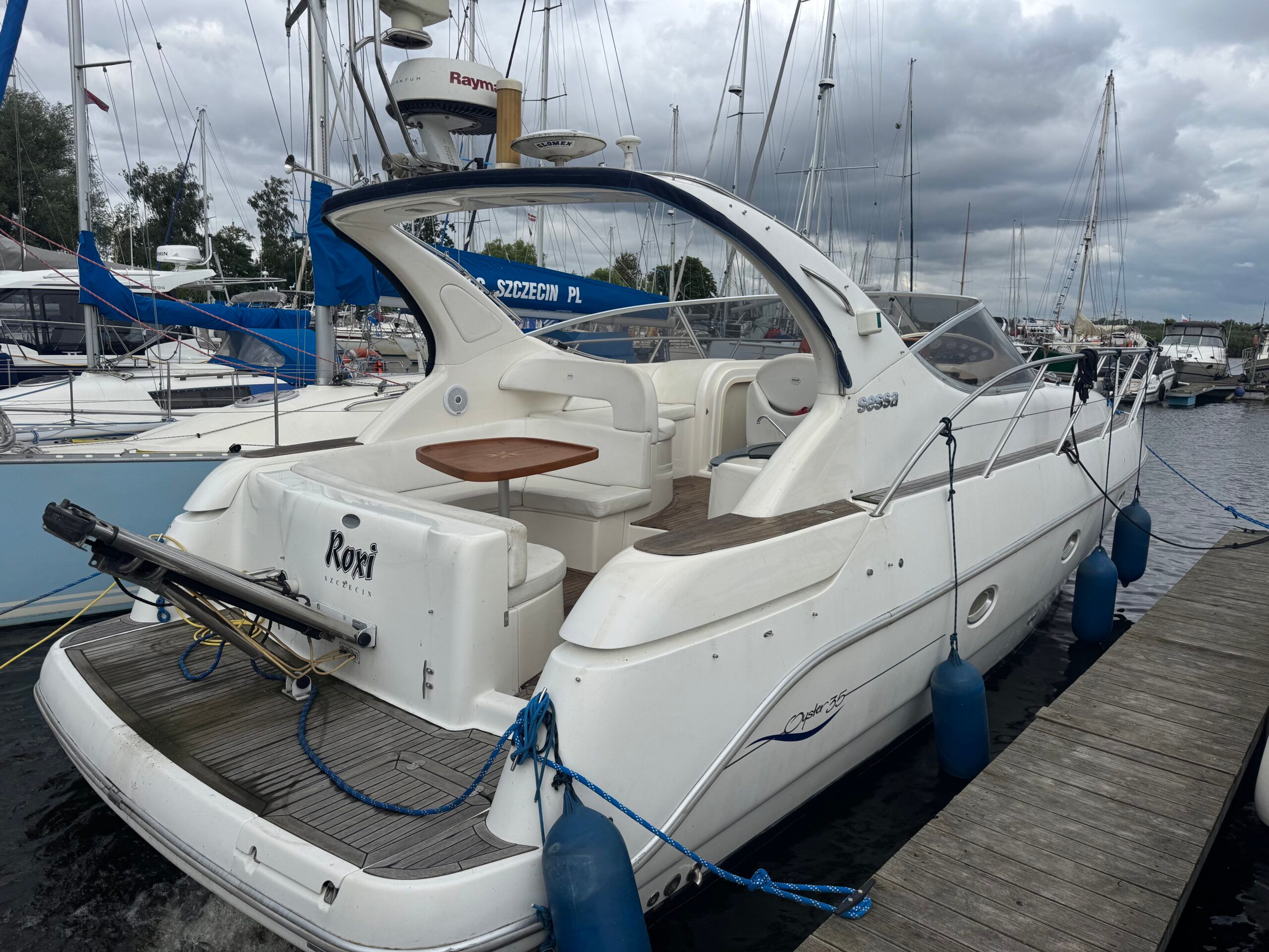 White Sessa 35 Oyster motor yacht moored in a marina, rear and side view. Cockpit and swim platform visible.