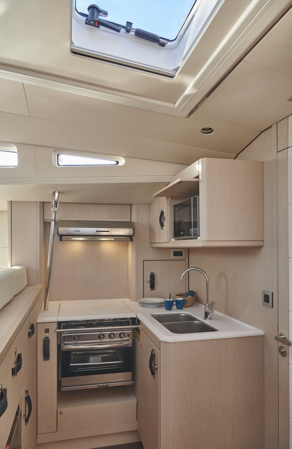 Kambuz jachtu Jeanneau Yachts 60 z kuchenką, piekarnikiem, zlewem i mikrofalówką.
