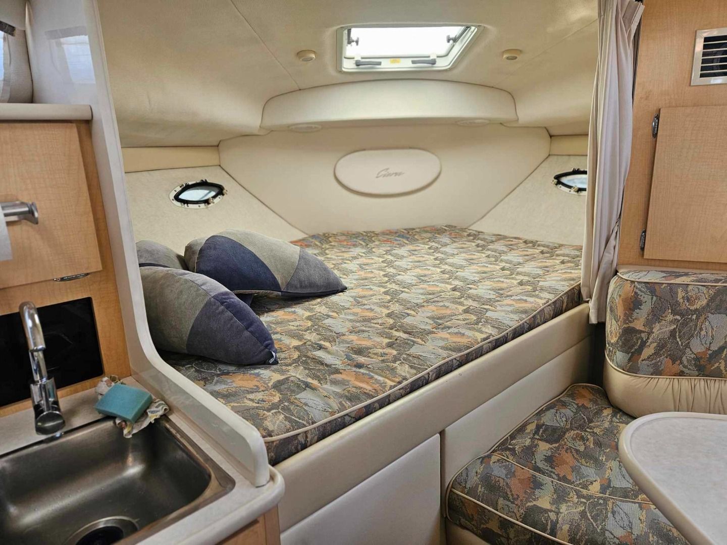 Innenraum der Bugkabine der Bayliner 3055 Ciera mit großer Koje und kleinem Waschbecken.