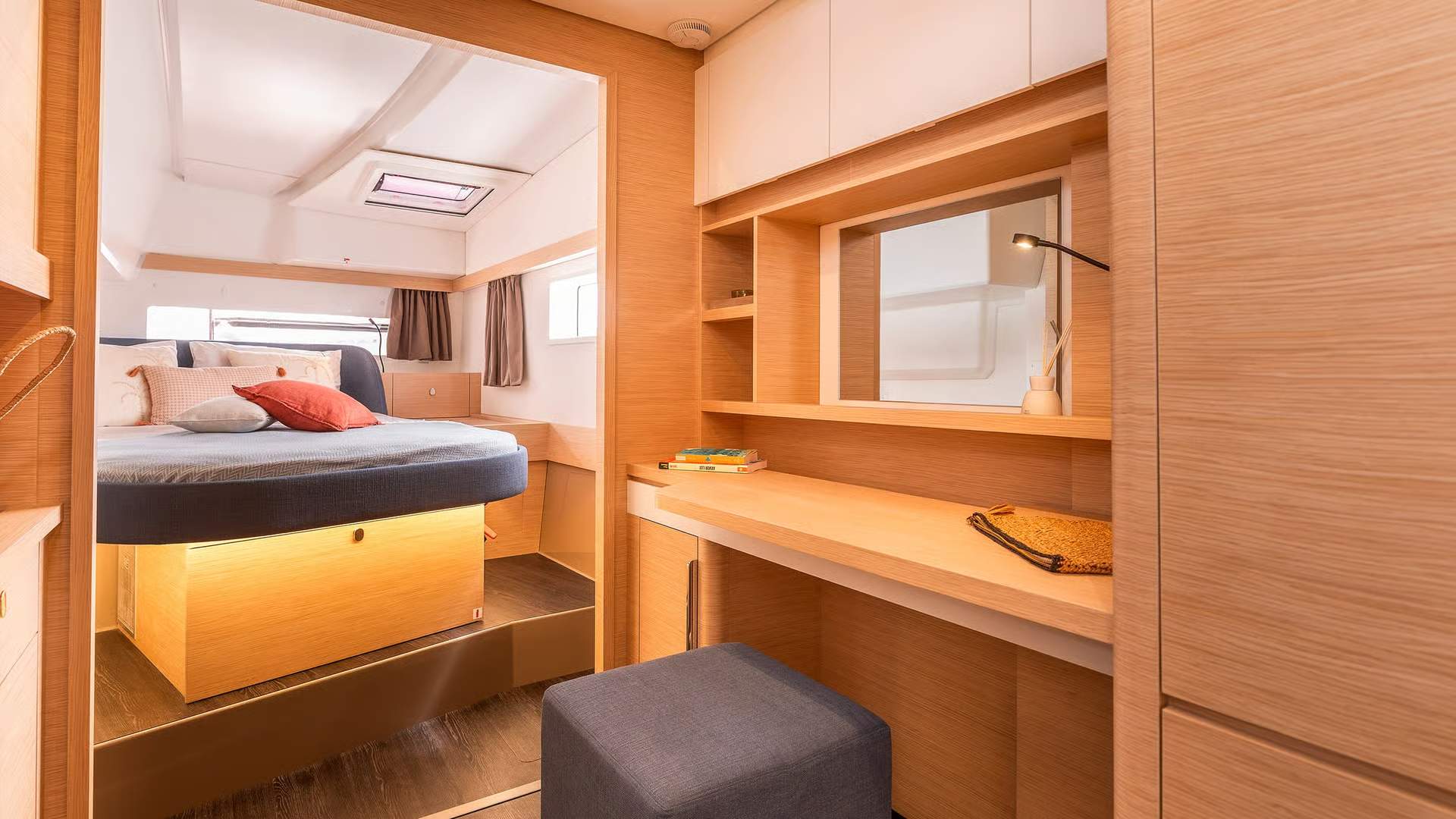 Innenraum einer Schlafkabine an Bord des Katamarans Fountaine Pajot FP41 mit Bett und Schreibtisch.