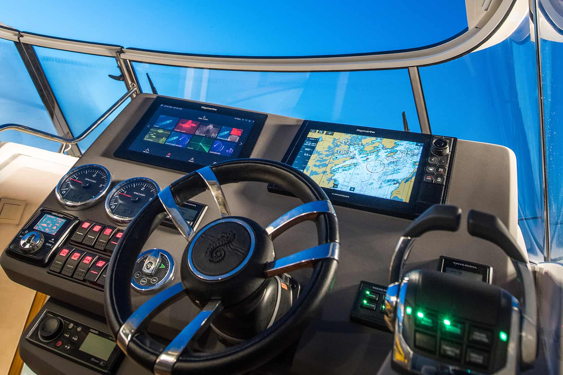 Steuerstand der Motoryacht Marex 360 mit Steuerrad, zwei Raymarine-Navigationsbildschirmen und Bedienpaneelen.