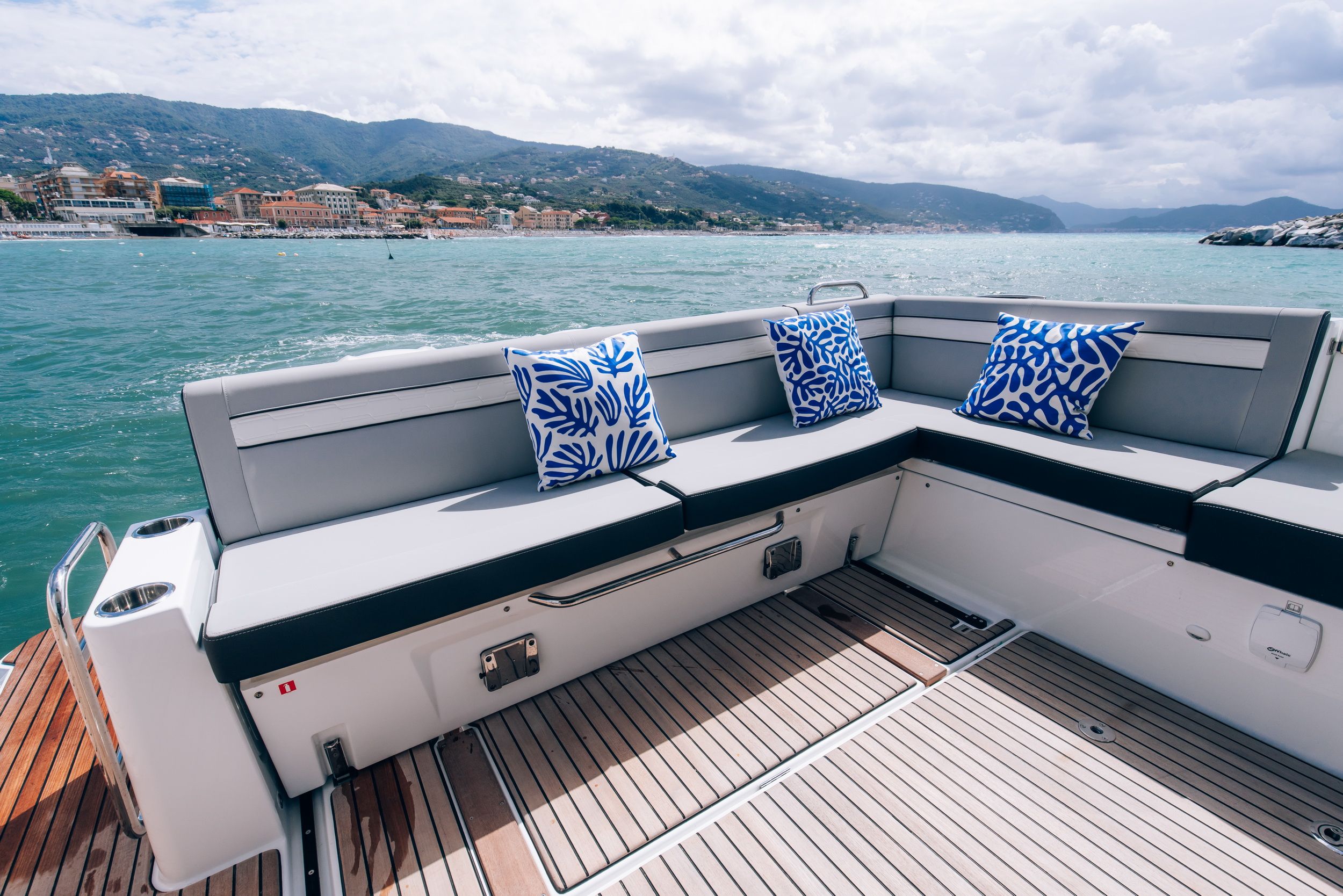 Spacious aft cockpit of the Jeanneau Merry Fisher 1095 Fly Serie2 with a comfortable L-shaped sofa and cushions.