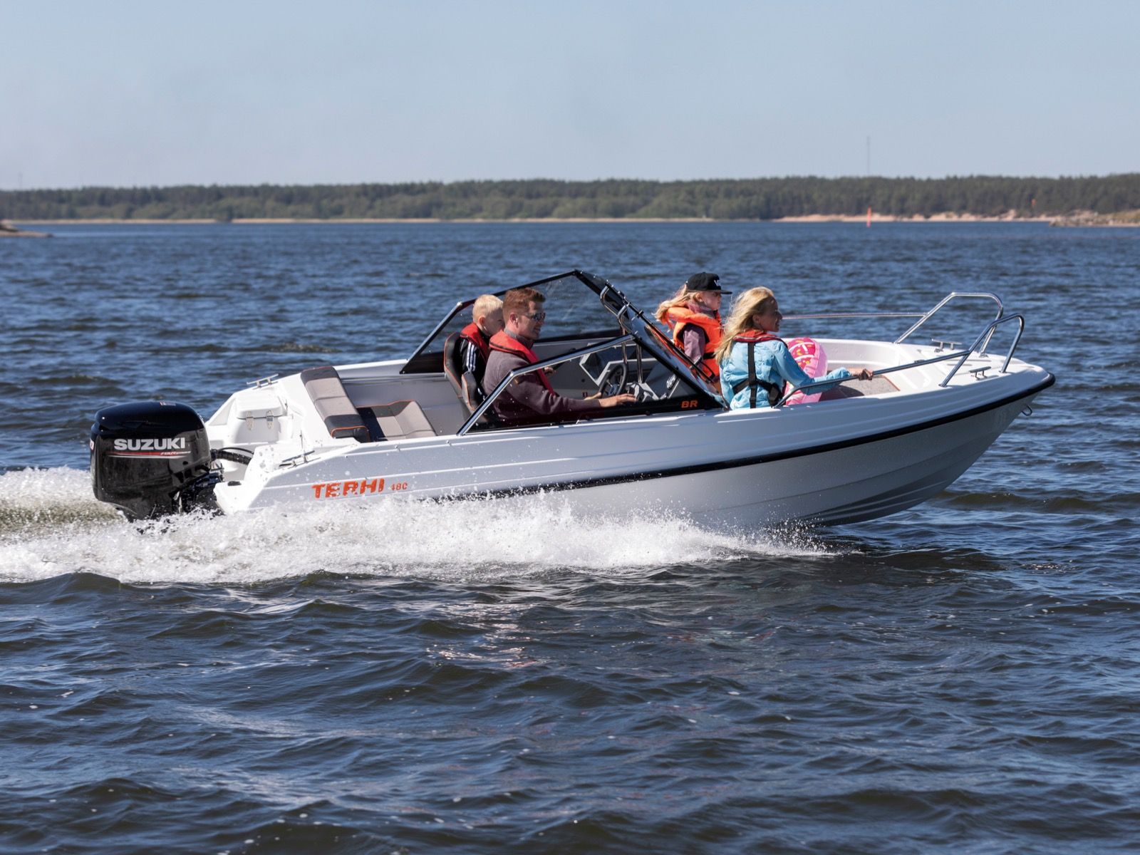 White Terhi 480 BR motorboat with a Suzuki motor sailing on the water with passengers wearing life jackets.