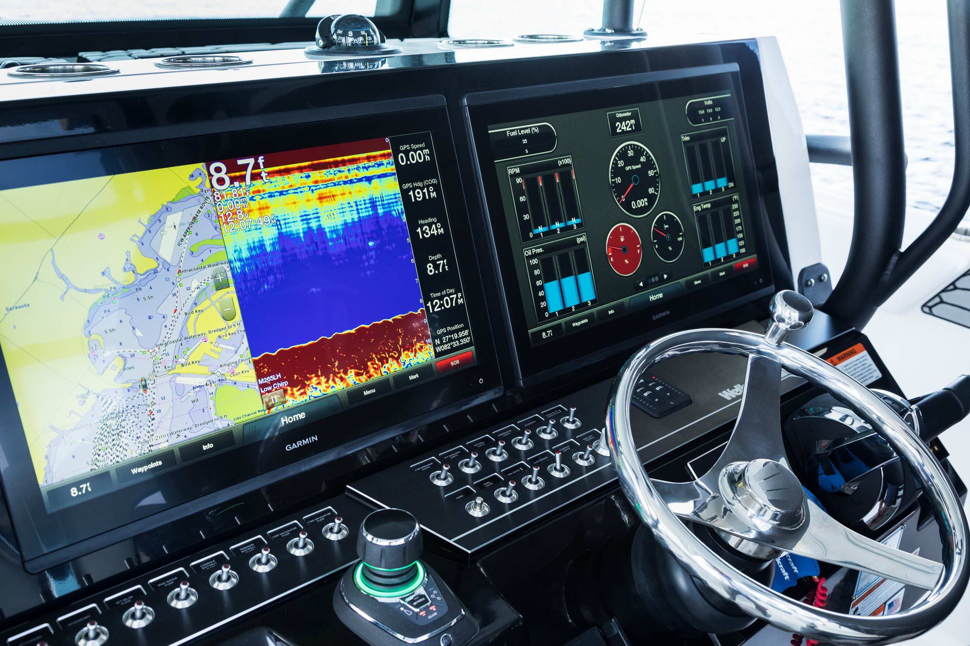 Kokpit łodzi Wellcraft Fisherman 352 z dwoma dużymi ekranami nawigacyjnymi Garmin i kierownicą.