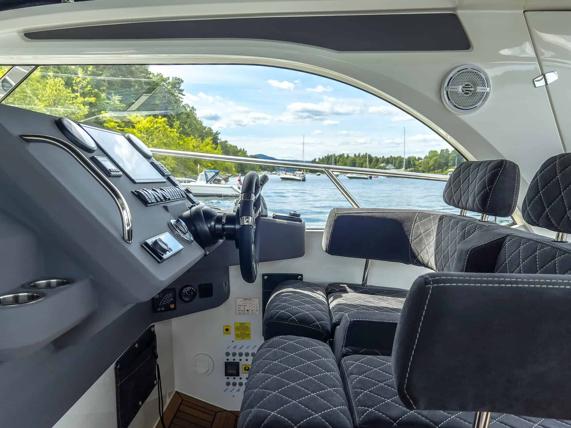 Interior of the Marex 310 Sun Cruiser, view of the helm station with dashboard and the fold-out cockpit seating.