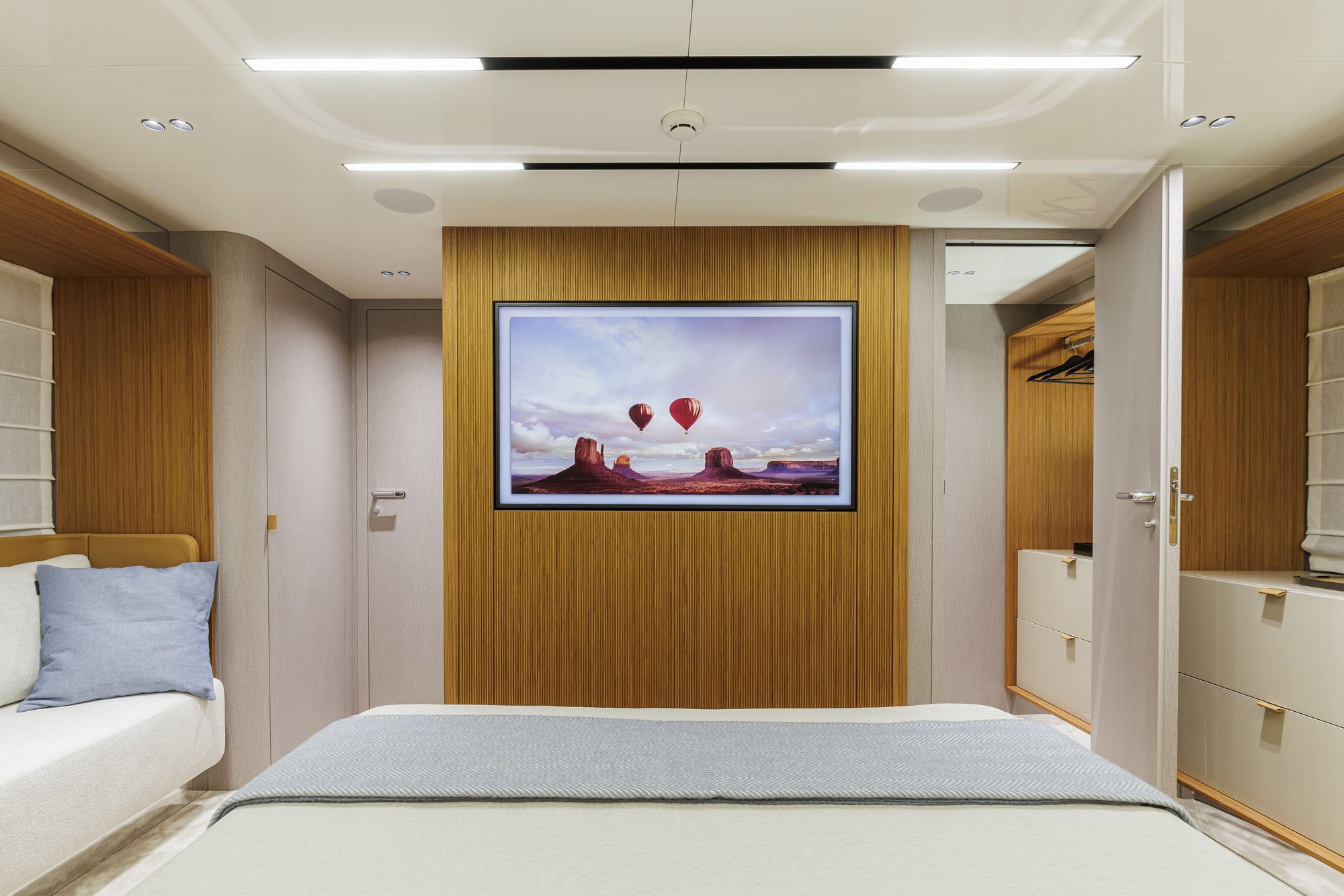 Interior of the owner's cabin aboard the Cranchi Sessantadue 62 with a large bed, TV and wardrobe.