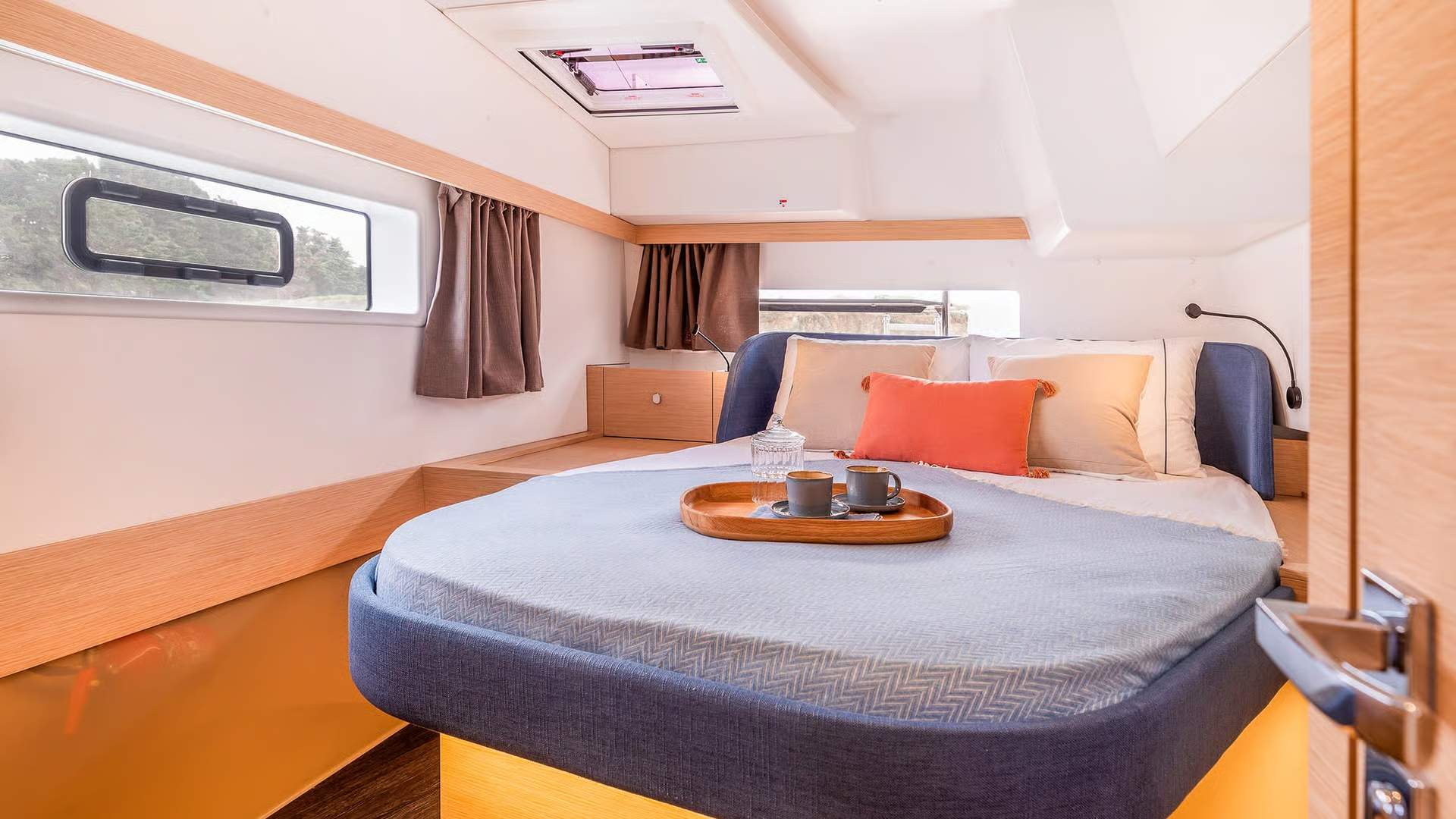 Wnętrze kabiny sypialnej katamaranu Fountaine Pajot FP41 z dużym łóżkiem, oknami i świetlikiem.