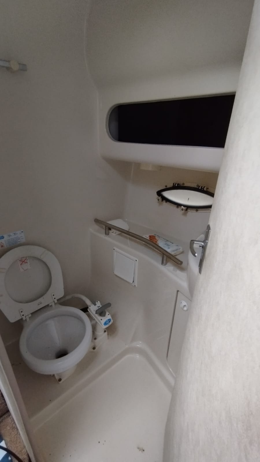 Wnętrze kabiny WC na jachcie Bayliner 3055 z toaletą morską i brodzikiem prysznicowym.
