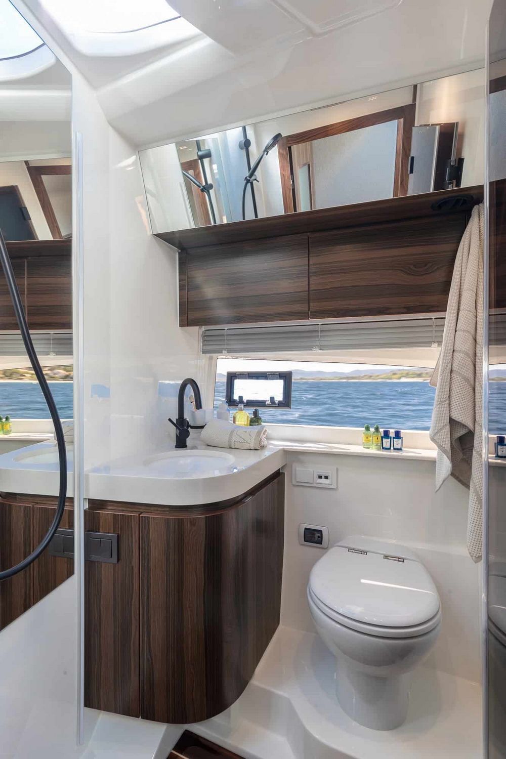 Moderne Bad-Kabine auf der Marex 440 Gourmet Cruiser mit Waschbecken, Toilette und Dusche, mit Meerblick.