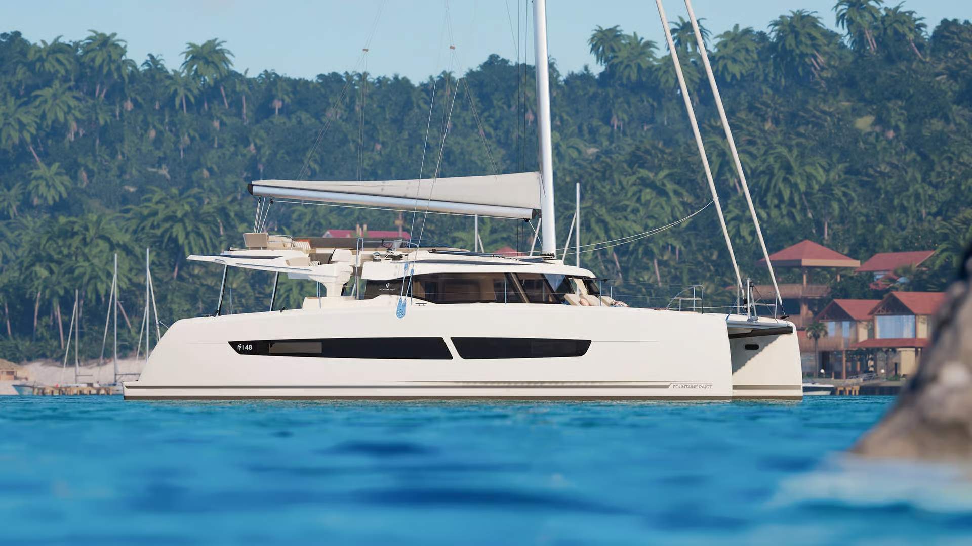 Biały katamaran żaglowy Fountaine Pajot FP48 na tle tropikalnej wyspy z palmami i budynkami, unoszący się na turkusowej wodzie.