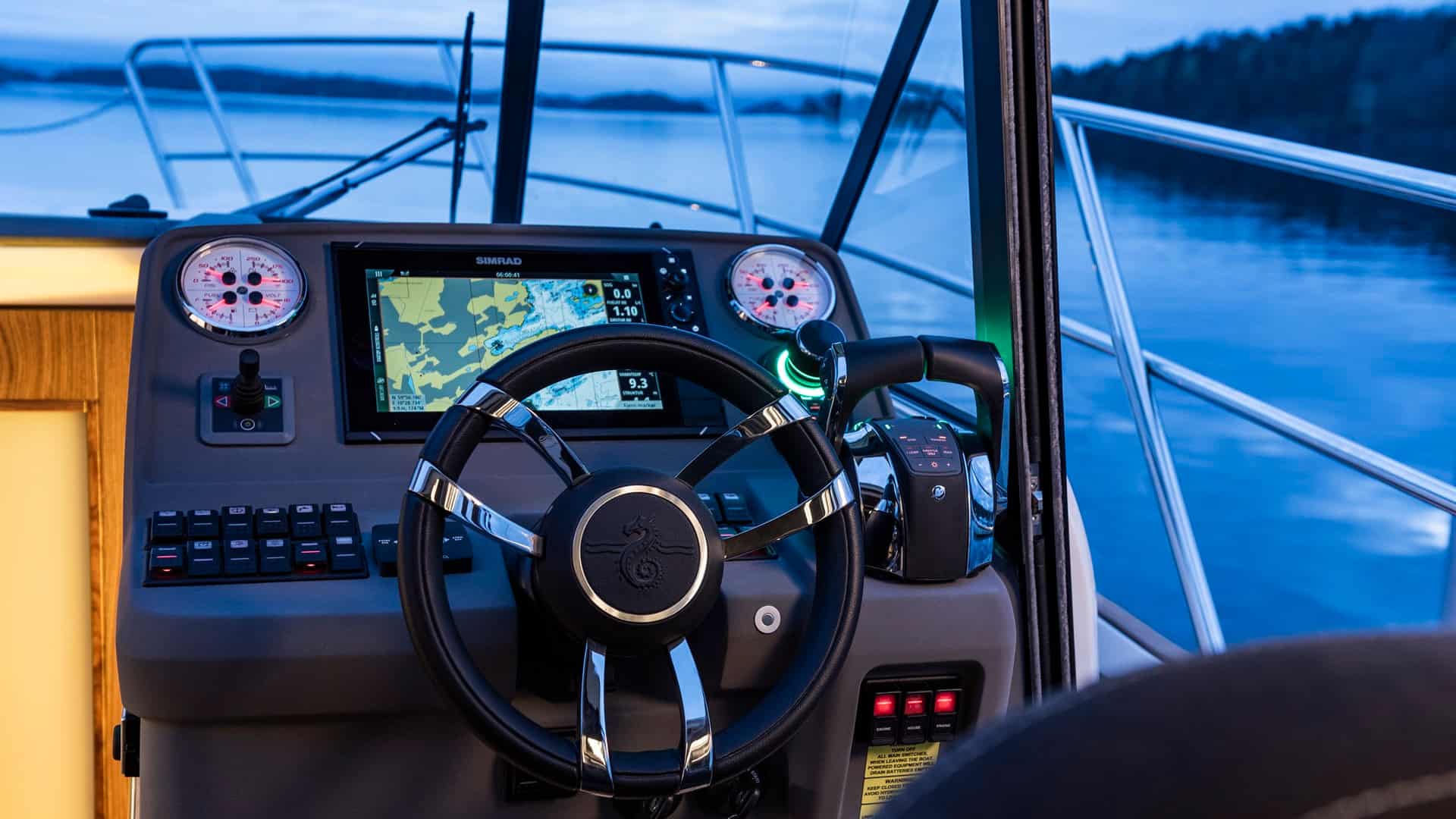 Blick auf den Steuerstand der Motoryacht Marex Scandinavia 330 mit Steuerrad, Navigationsdisplay und Bedienelementen.