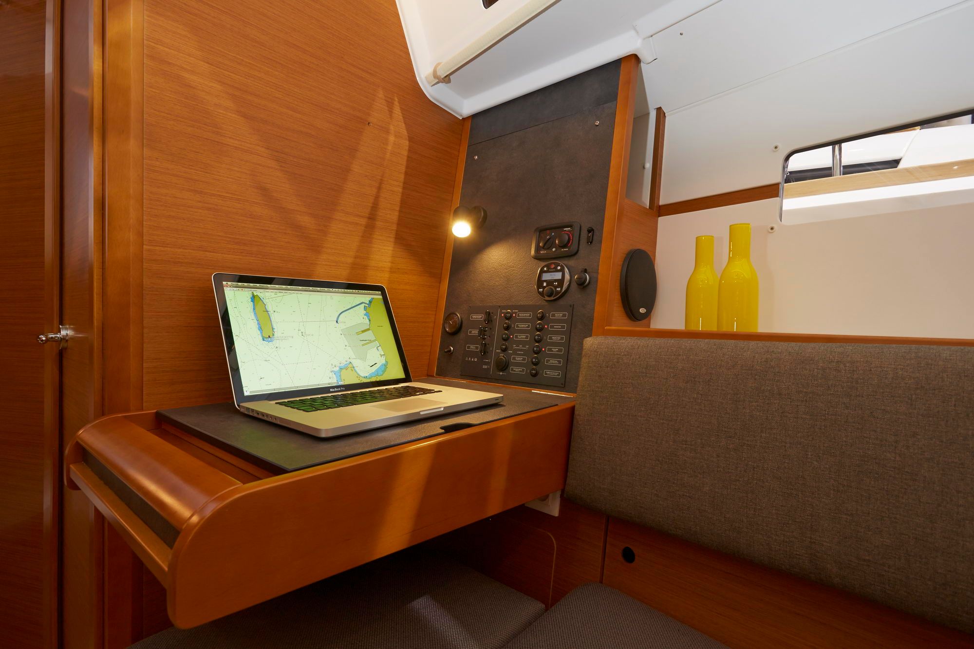 Interior of the Jeanneau Sun Odyssey 349: chart table with laptop and control panel.